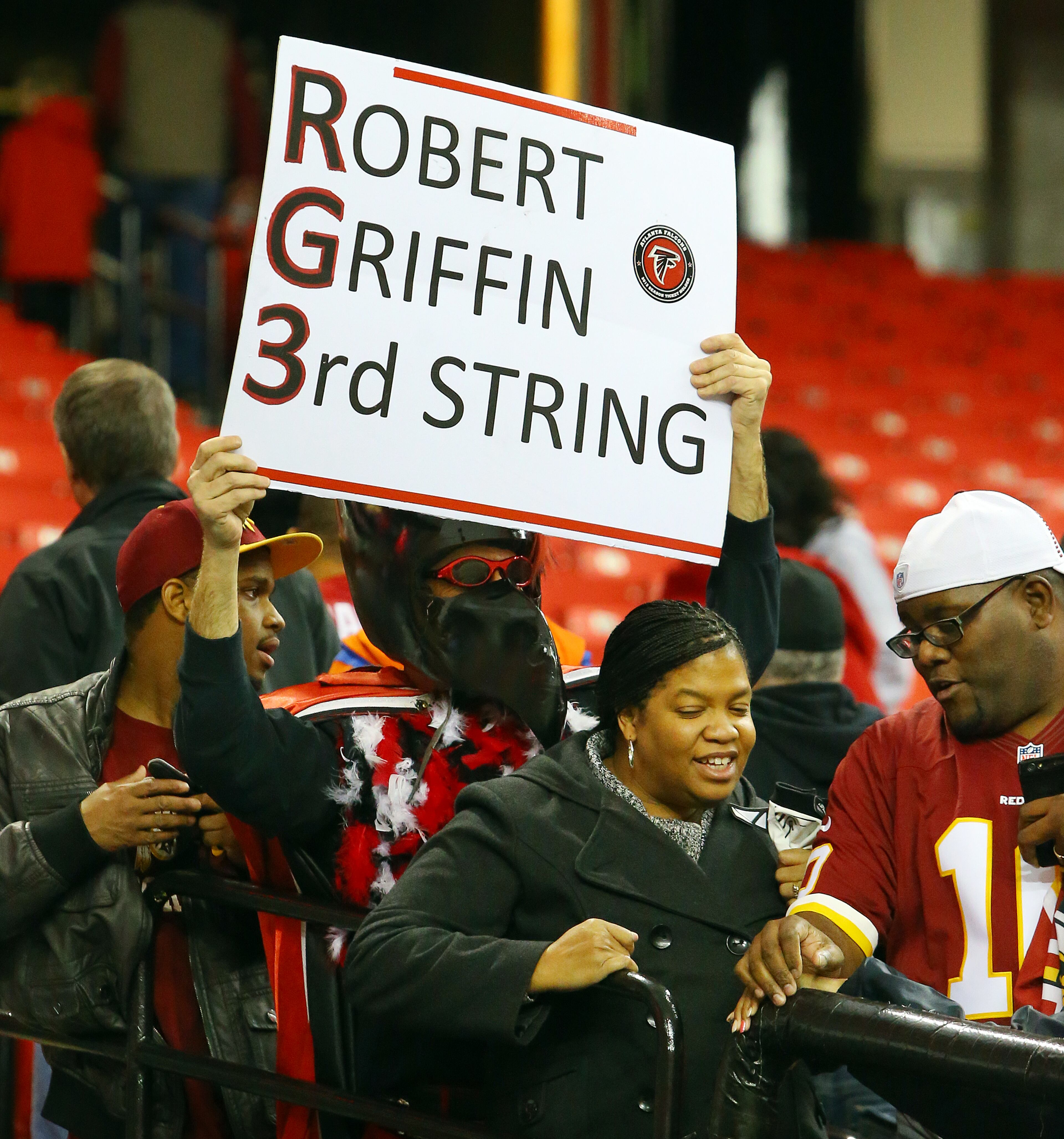 A Falcons fan taunts Redskins fans with a Robert Griffin III sign after the Falcons downed the Redskins 27-26 during the second half of a NFL football game on Sunday, Dec. 15, 2013, in Atlanta.