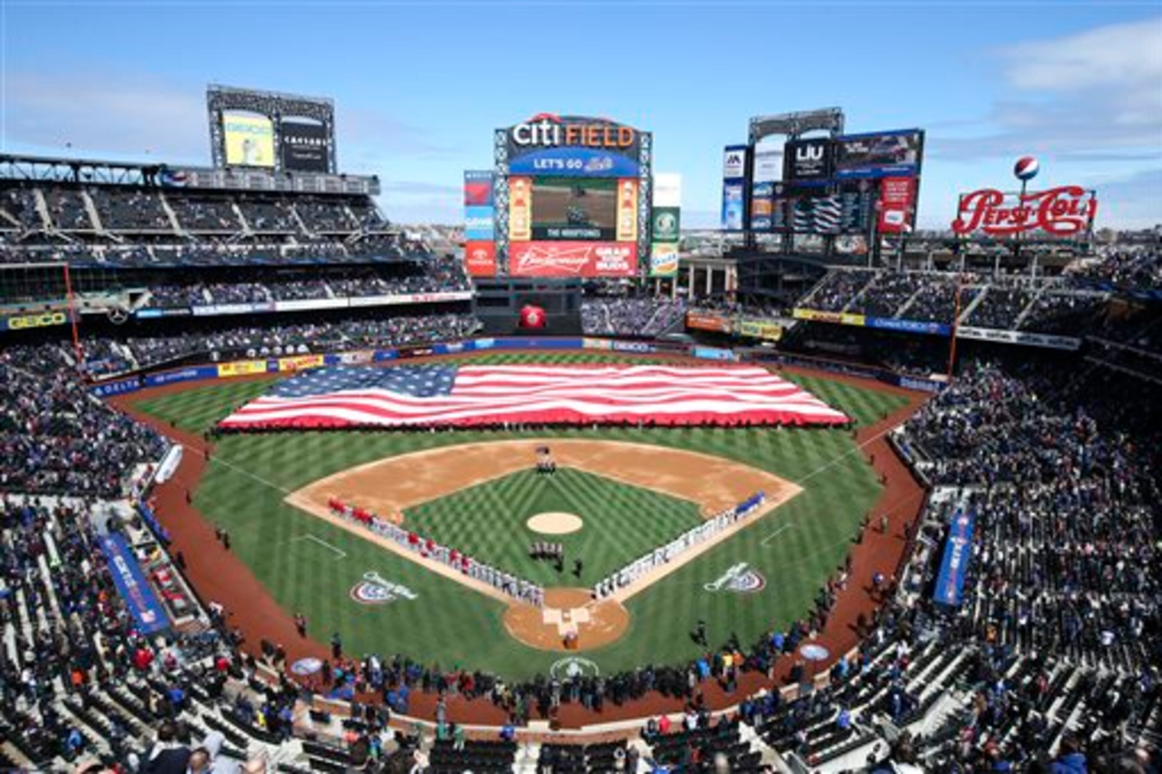 A giant American flag is unfurled before a baseball game between the New York Mets and Washington Nationals on opening day at Citi Field, Monday, March 31, 2014, in New York. (AP Photo/John Minchillo)