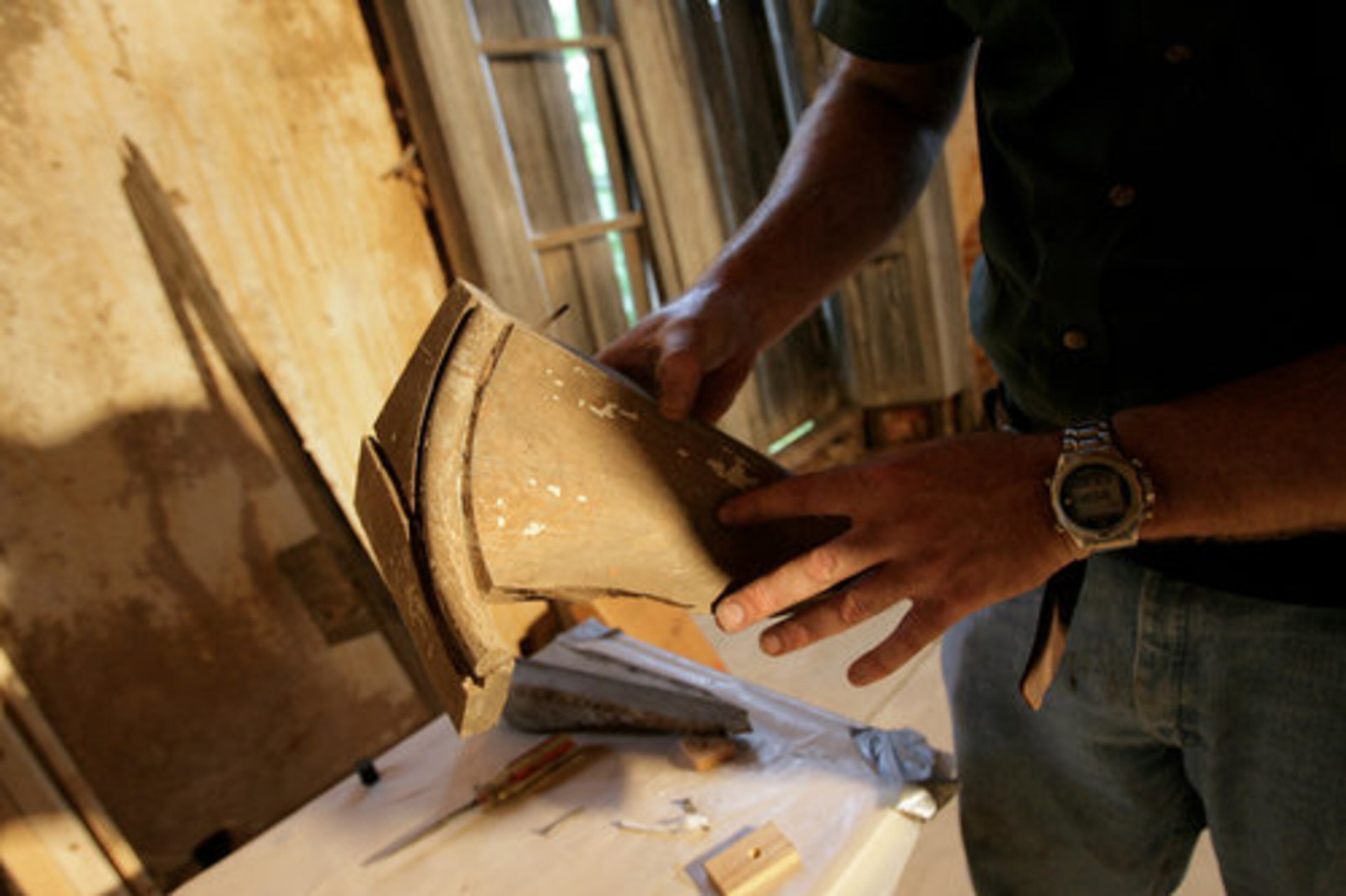 Fagan holds an original handcarved cornice. It will be used as a model for new handcarved versions used in the renovation of Grant Mansion.