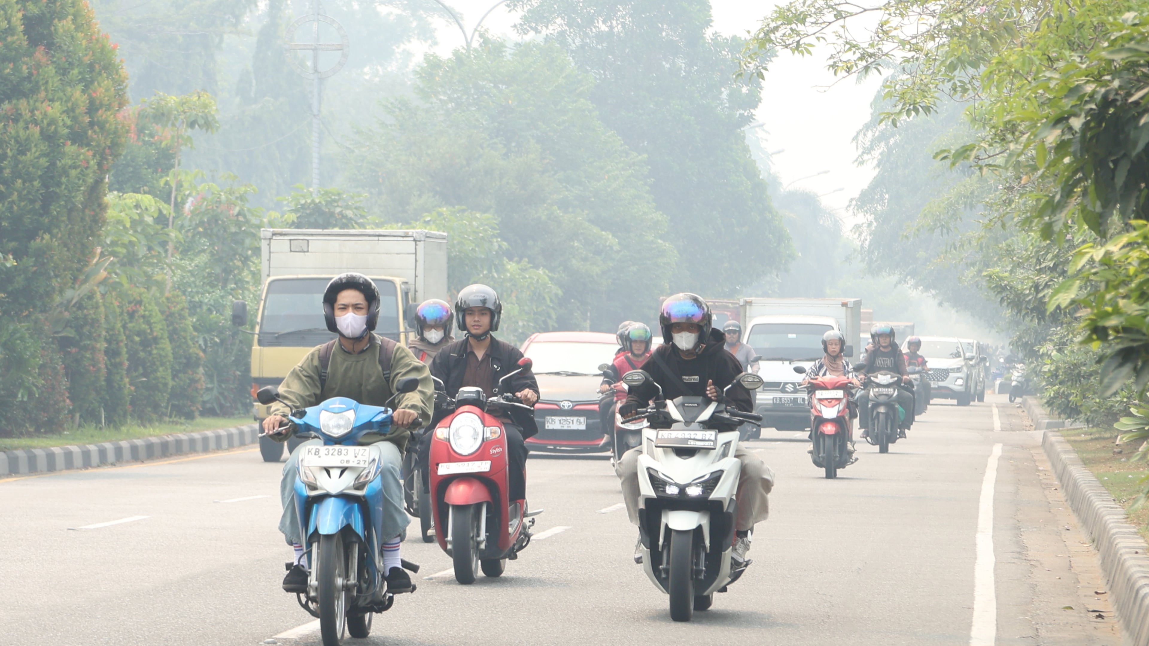 Motorists ride on a road as haze from wildfires blanket the city of Pontianak, West Kalimantan, Indonesia, Friday, Aug. 21, 2026. (AP Photo/Stefanus Taman)