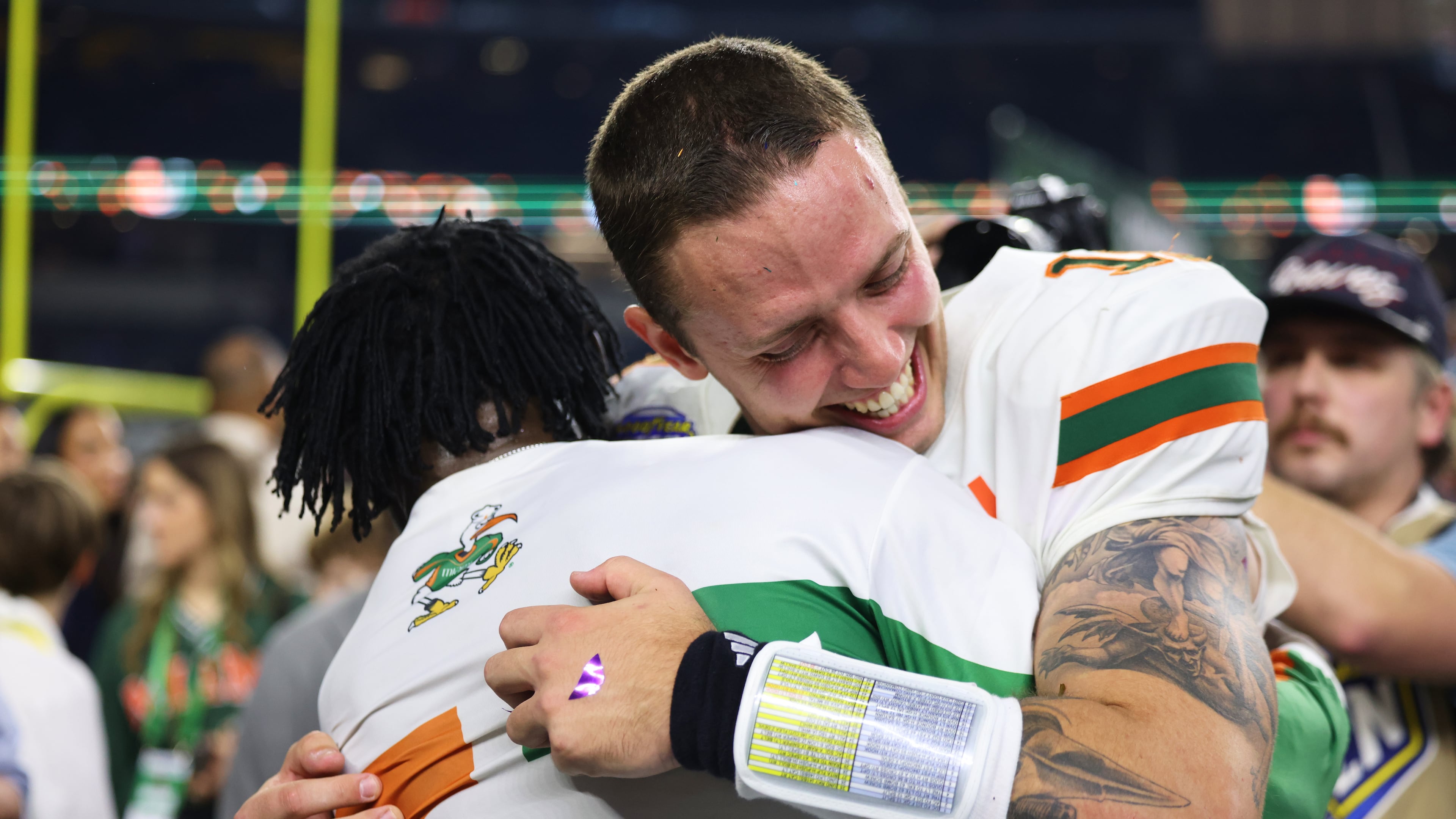 Miami quarterback Carson Beck, right, is hugged by former NFL player Michael Irvin following the Cotton Bowl College Football Playoff quarterfinal game against Ohio State Wednesday, Dec. 31, 2025, in Arlington, Texas. (AP Photo/Gareth Patterson)