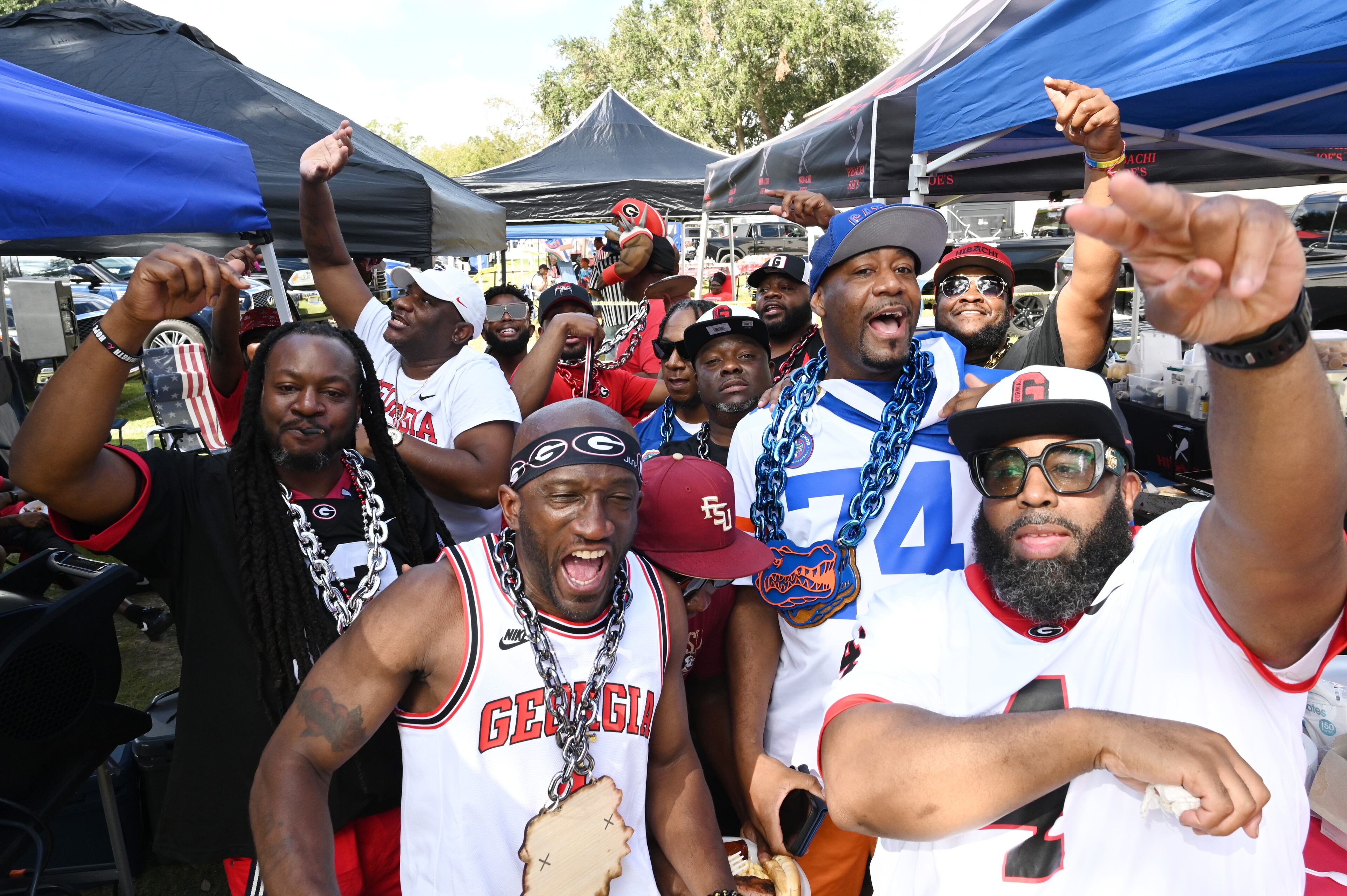 Georgia fans cheer as Tony Swinson, a.k.a DJ SWIN, (not pictured) plays tunes outside EverBank Stadium ahead of the NCAA football game between Georgia and Florida, Saturday, November 2, 2024, in Jacksonville, Fla. (Hyosub Shin / AJC)