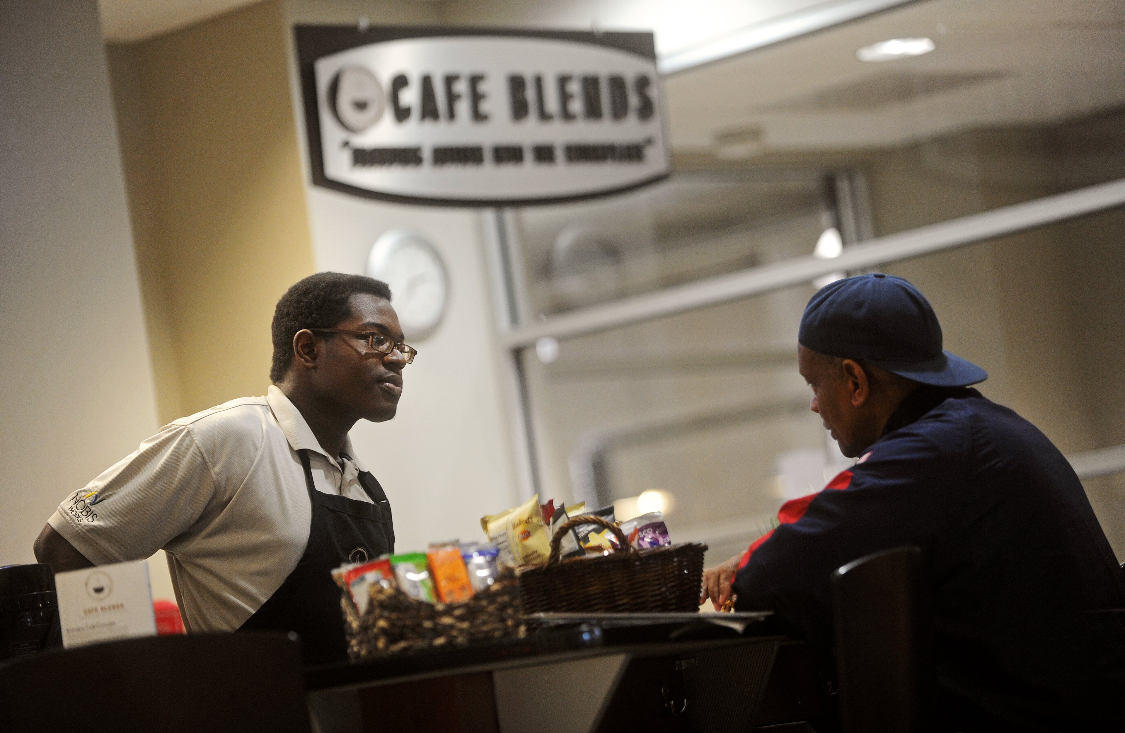 Omar chats with customer Dwight Lee at Cafe Blends, a cafe that provides jobs for people on the autism spectrum, at Nalley Lexus Smyrna. The cafe serves complimentary coffees and other treats for customers of the car dealership.