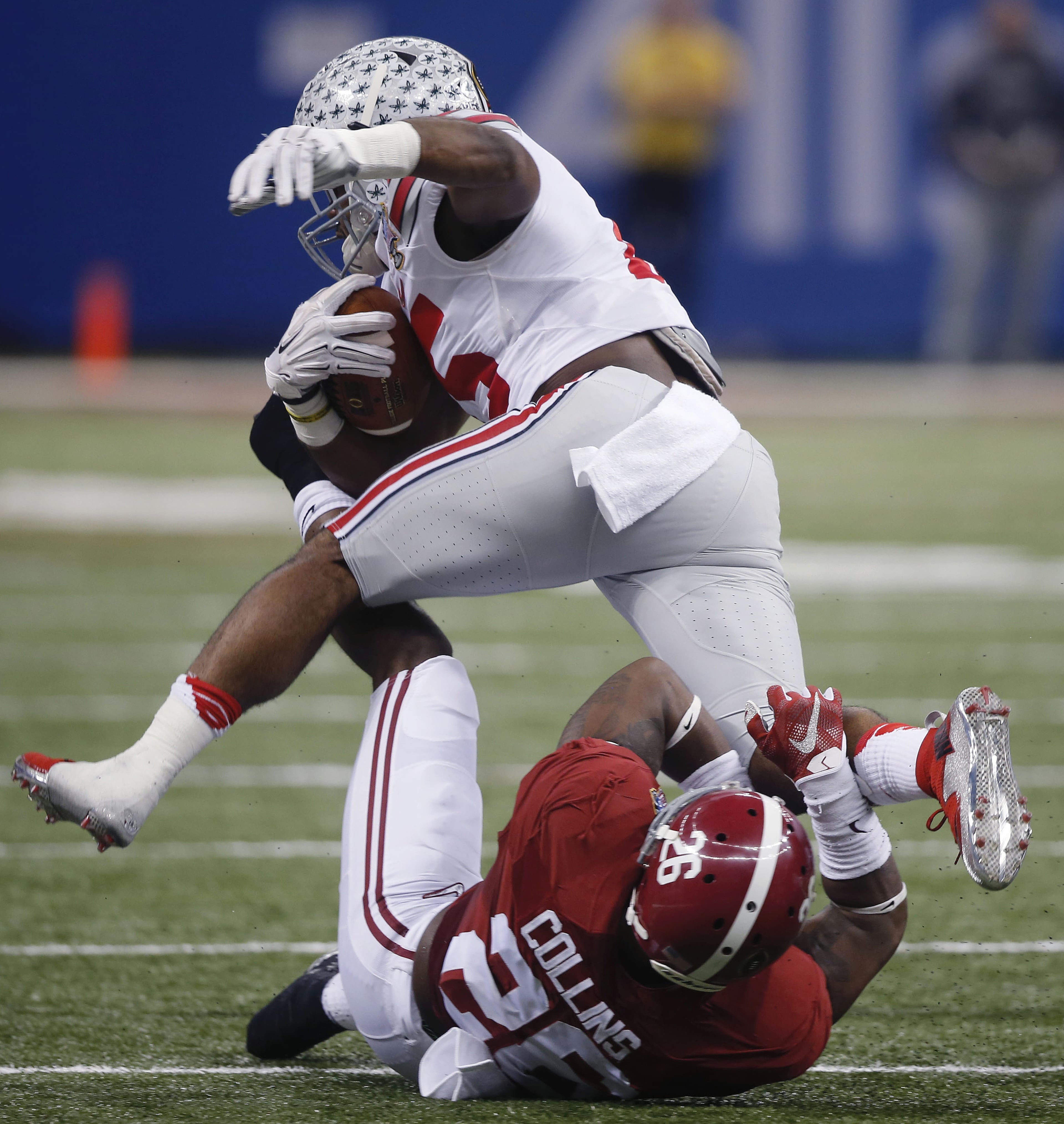 Ohio State running back Bri'onte Dunn (25) runs over Alabama defensive back Landon Collins (26) in the first half of the Sugar Bowl NCAA college football playoff semifinal game, Thursday, Jan. 1, 2015, in New Orleans. (AP Photo/Bill Haber)