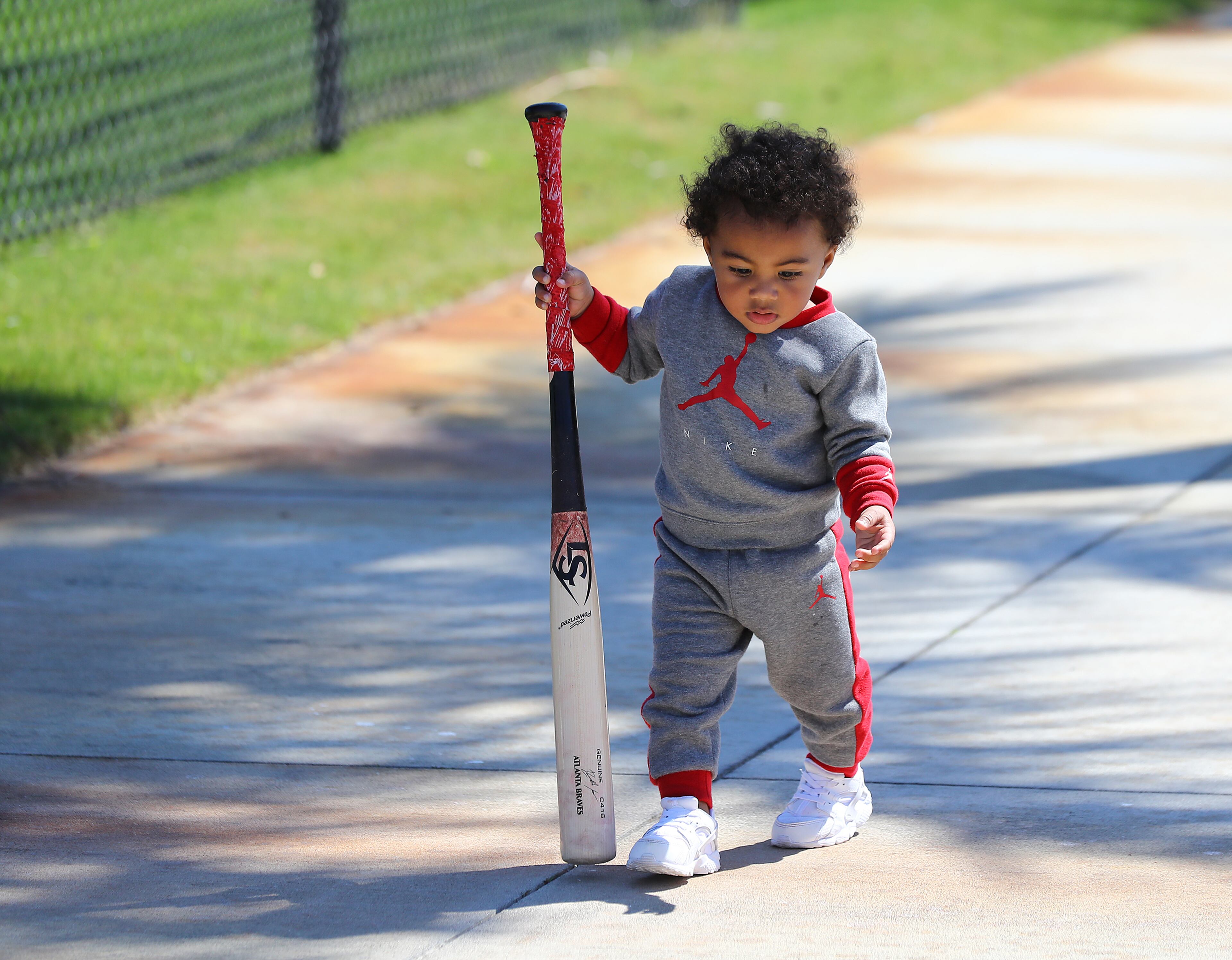 Ronald Acuna Jr. II, the son of Braves outfielder Ronald Acuna, carries his dad's bat in for him after the end of practice for the day during Spring Training on Thursday, March 17, 2022, in North Port. “Curtis Compton / Curtis.Compton@ajc.com”