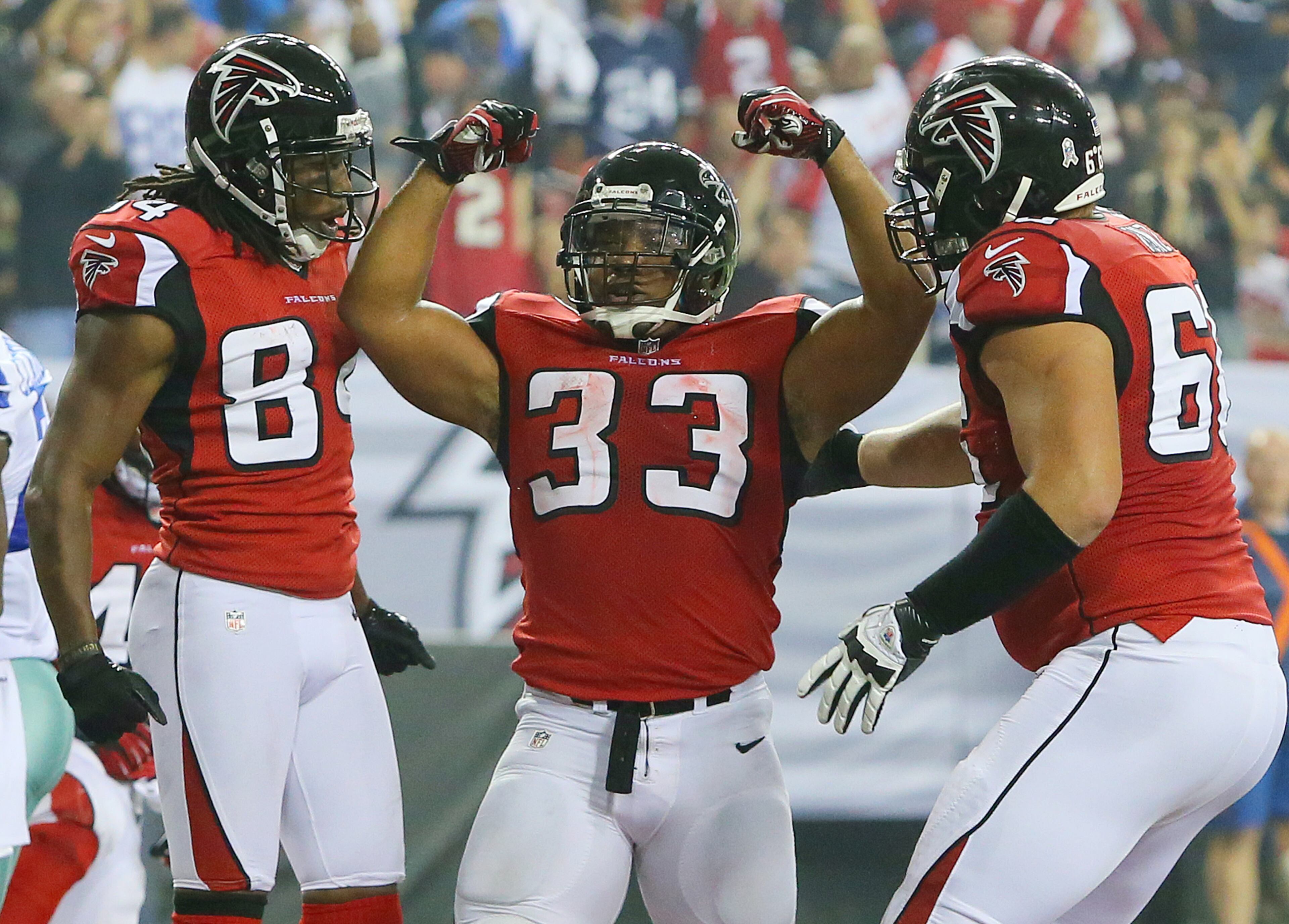Falcons running back Michael Turner flexes in the end zone celebrating his touchdown with Roddy White (left) and Peter Konz, to take a 13-6 lead during fourth quarter action at the Georgia Dome.