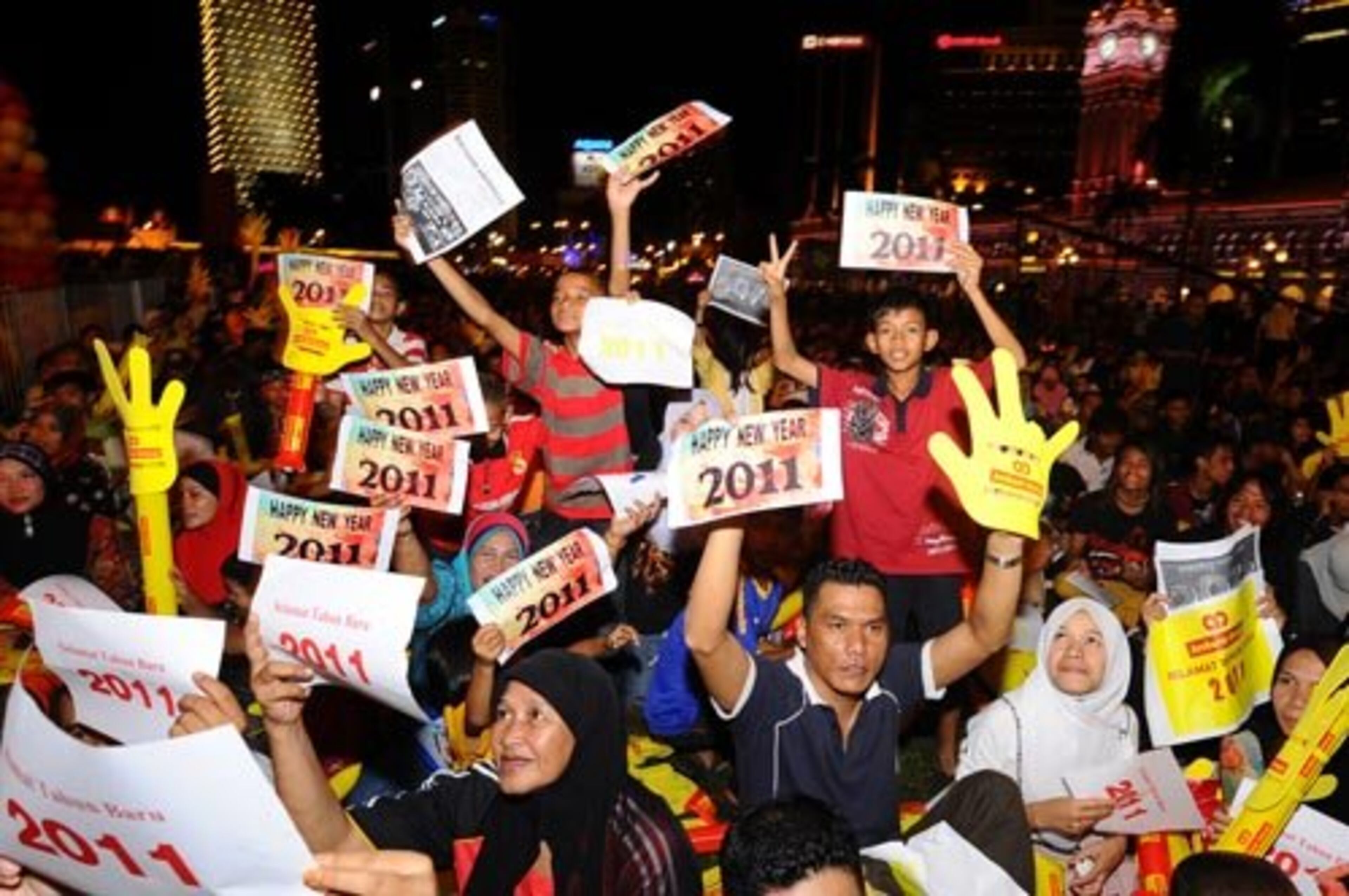 People gather in in downtown Kuala Lumpur, Malaysia, holding placards reading "Happy New Year 2011" in anticipation of the clock striking midnight.
