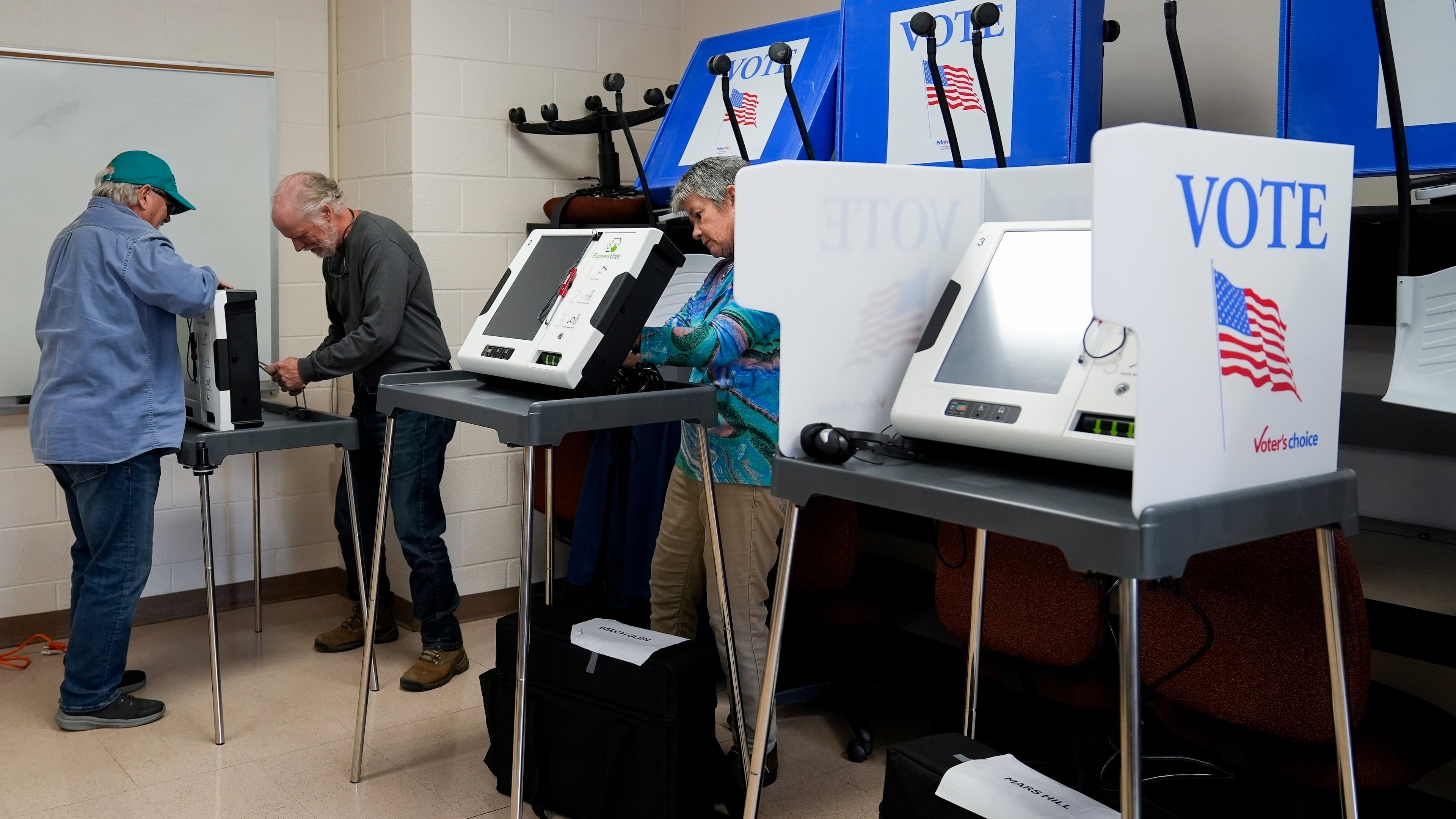 FILE - Poll workers set up ballot-marking machines at an early in-person voting site at Asheville-Buncombe Technical Community College, Oct. 16, 2024, in Marshall, N.C. (AP Photo/Stephanie Scarbrough, File)