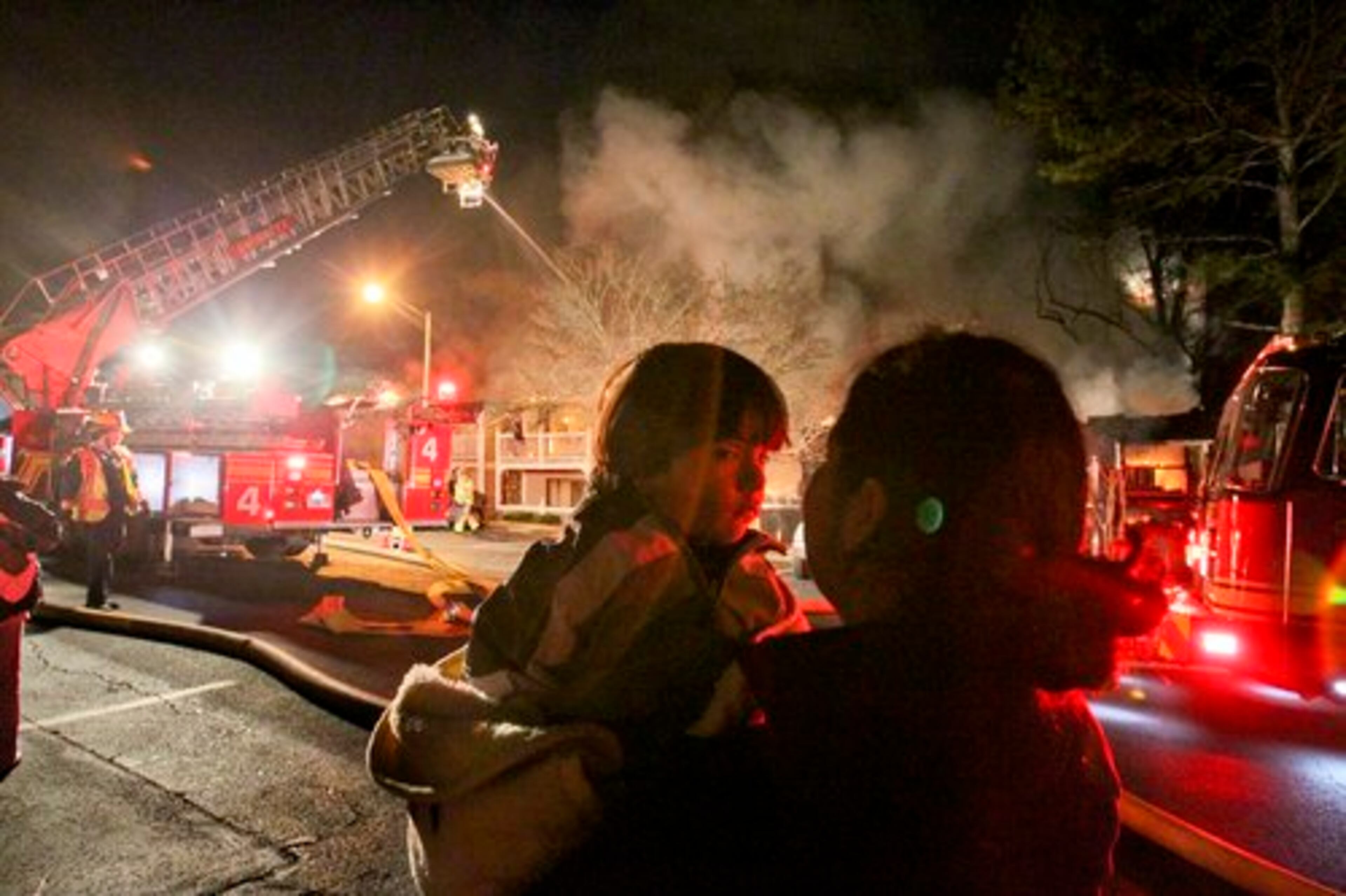 Eliana Coyote holds her child, Angel-3 as they watch their apartments burn Thursday.