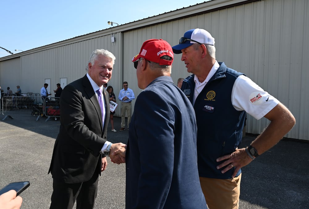 U.S. Rep. Mike Collins, left, is greeted by state Rep. Reynaldo Martinez and state Sen. Chuck Payne, right, before a campaign rally at Dalton Municipal Airport earlier this month. (Hyosub Shin/AJC)