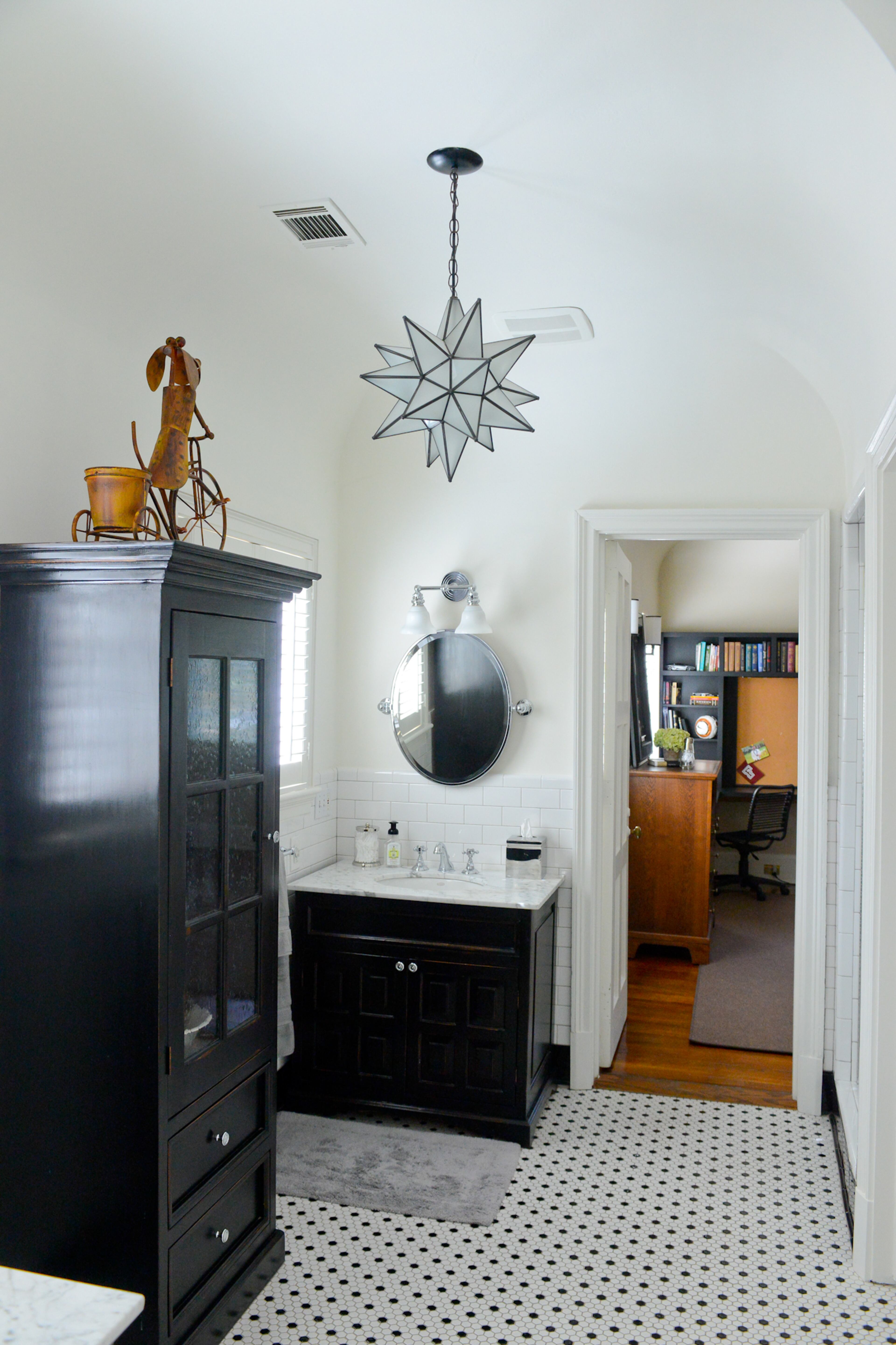 A renovated Jack-and-Jill bathroom in the East Lake home features a black-and-white color scheme and a mix of modern and period touches.