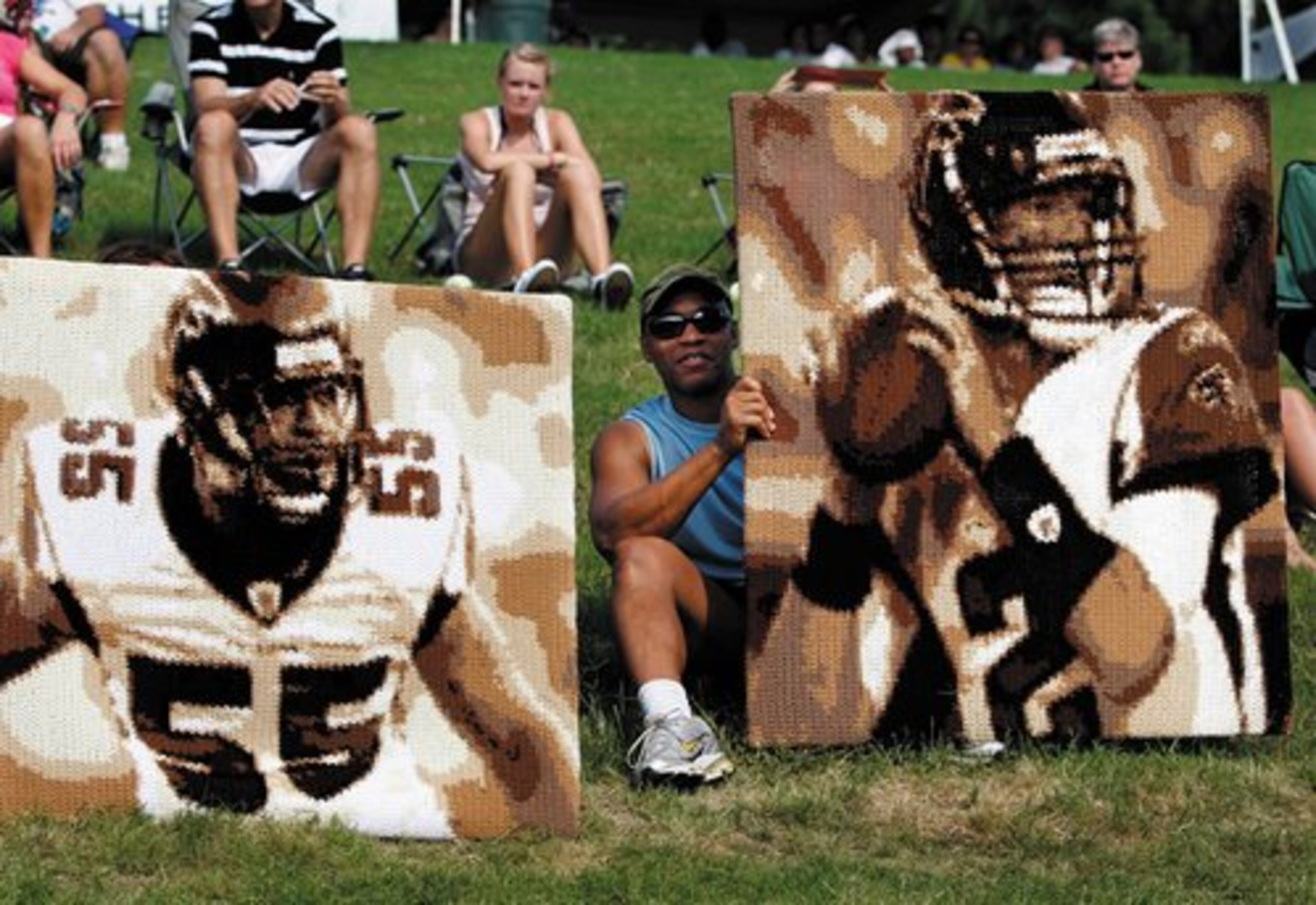 Fan Todd Paschall, who makes custom crochets, takes in the Falcons practice from the hill over looking the fields with some of his work depicting John Abraham and Matt Ryan.