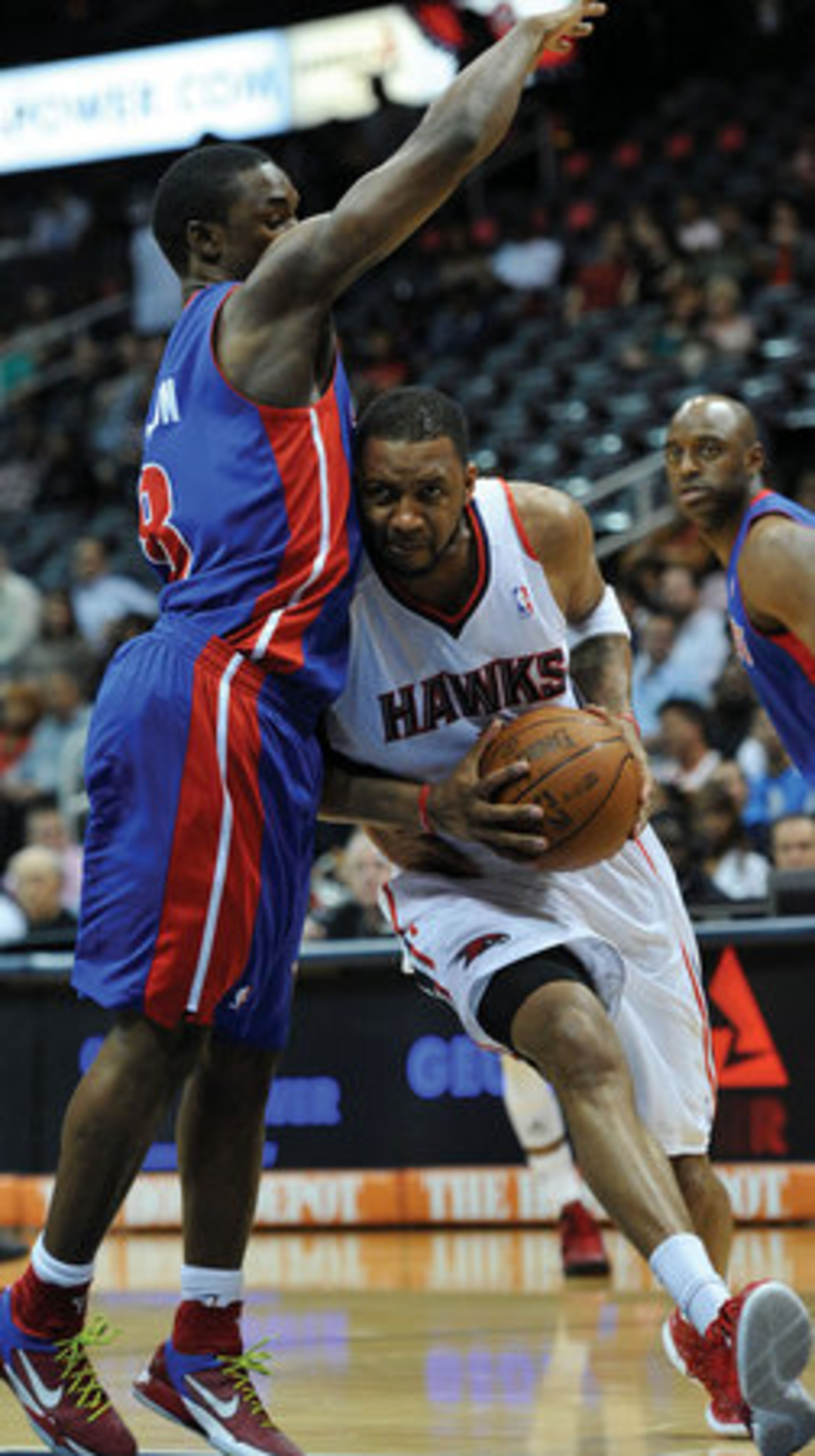 Tracy McGrady drives past Pistons player Ben Gordon.