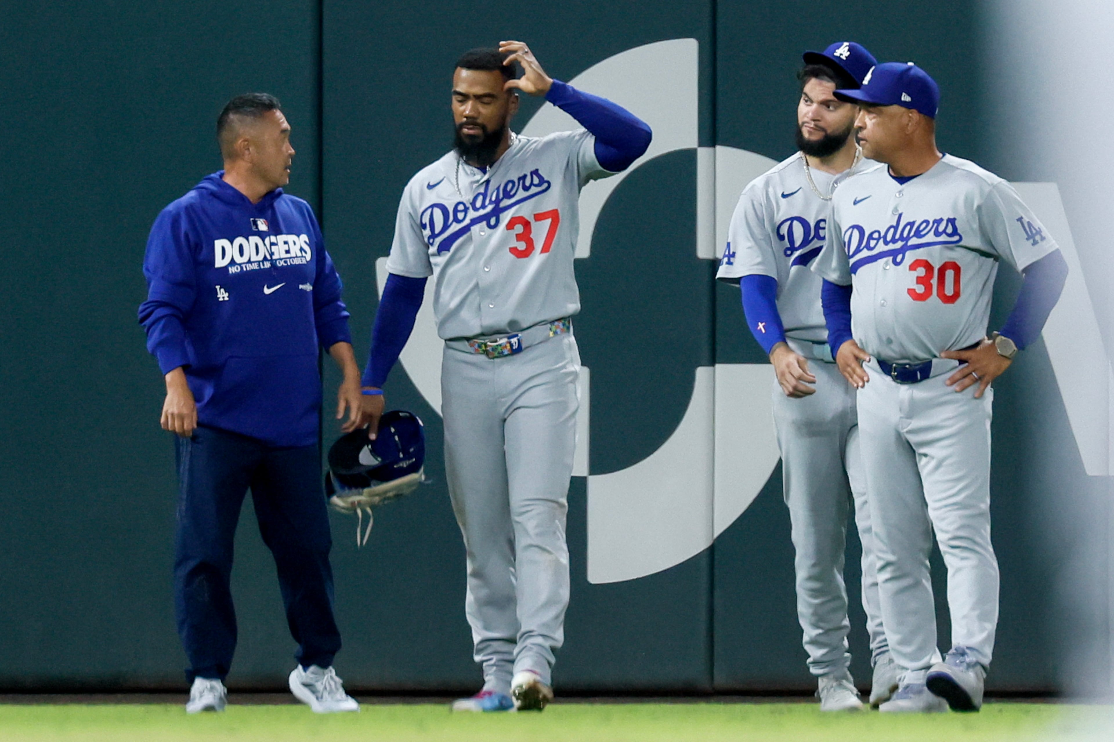 Los Angeles Dodgers left fielder Teoscar Hernandez (37) receives treatment after hitting the outfield wall while trying to catch a double hit by Atlanta Braves' Ozzie Albies during the sixth inning of Game 4 of the MLB National League Division Series between the Atlanta Braves and the Los Angeles Dodgers, Wednesday, Oct. 7, 2026, in Atlanta. (Miguel Martinez/AJC)