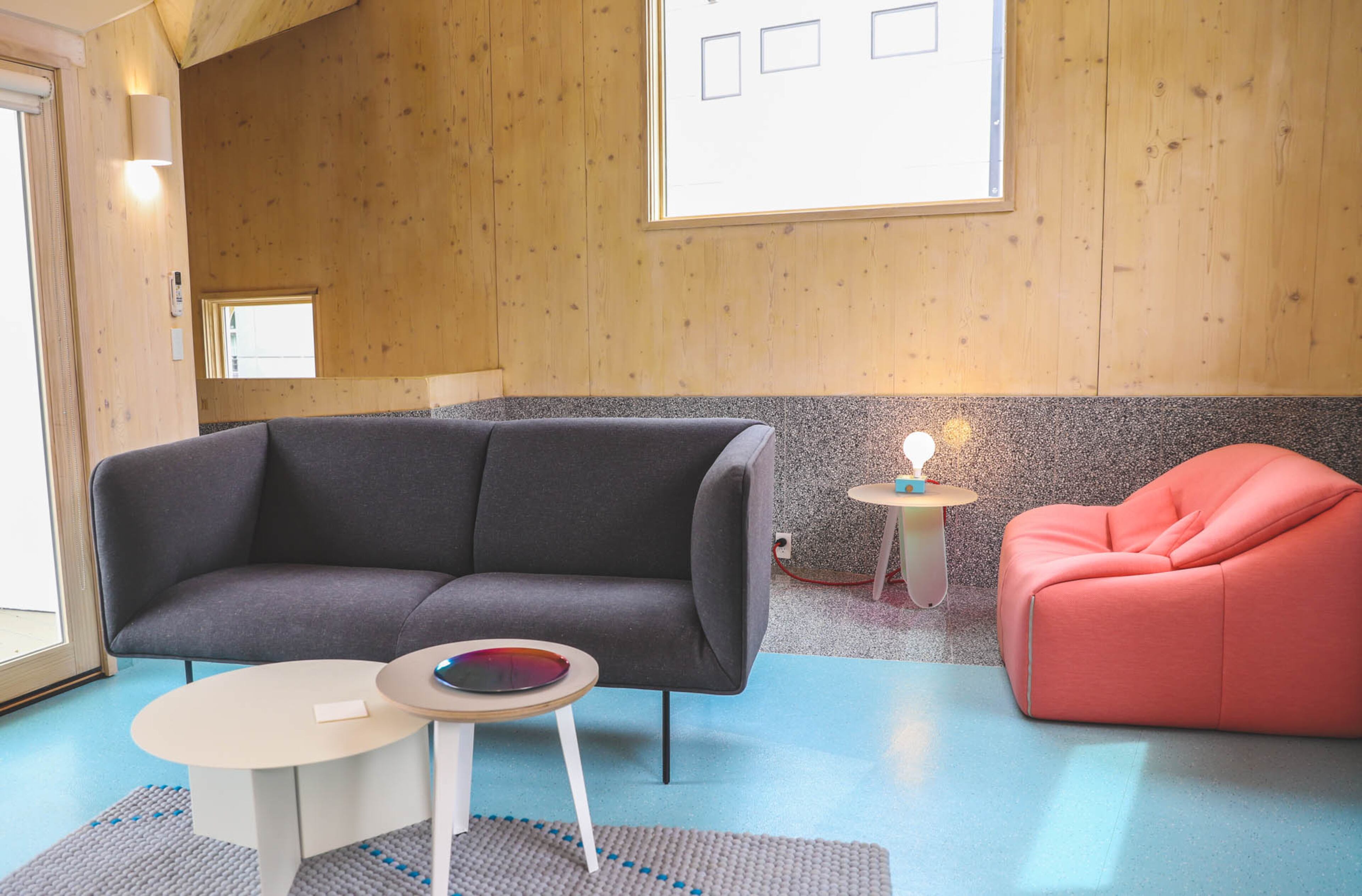 In the living room, the floors are made of Roundel Speckled vinyl tile by Johnsonite in a color called Caribbean Cruise. The charcoal Dandy sofa is by Blu Dot. The Slit table in XL by Hay is nestled under the Floyd side table from Floyd Home. The Dot rug, designed by Scholten + Baijings for Hay, picks up the blue in the floors.