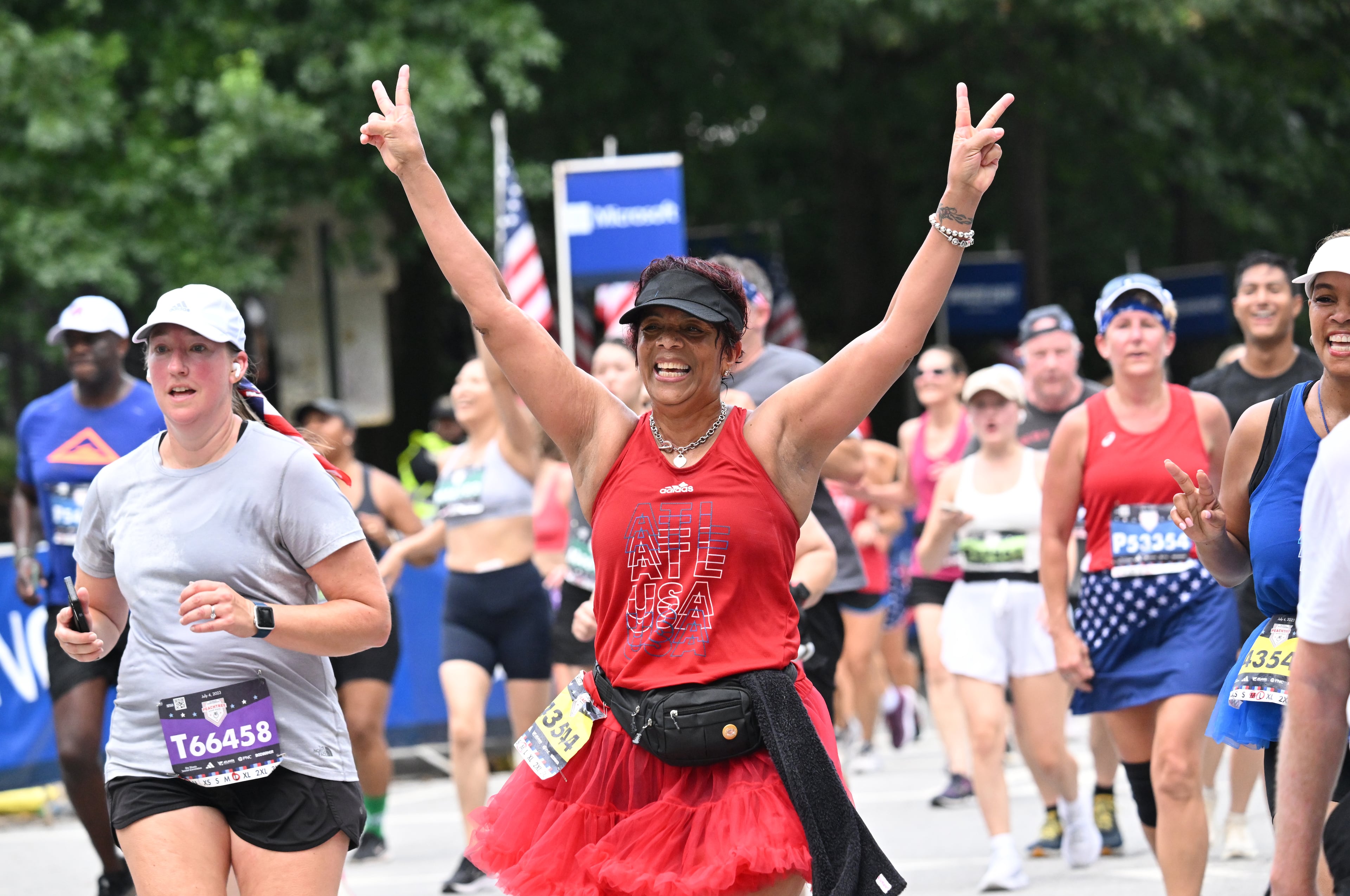 Runners celebrate as they cross the finish line of the 54th running of the Atlanta Journal-Constitution Peachtree Road Race during the 2023 Atlanta Journal-Constitution Peachtree Road Race, Tuesday, July 4, 2023, in Atlanta. (Hyosub Shin / Hyosub.Shin@ajc.com)