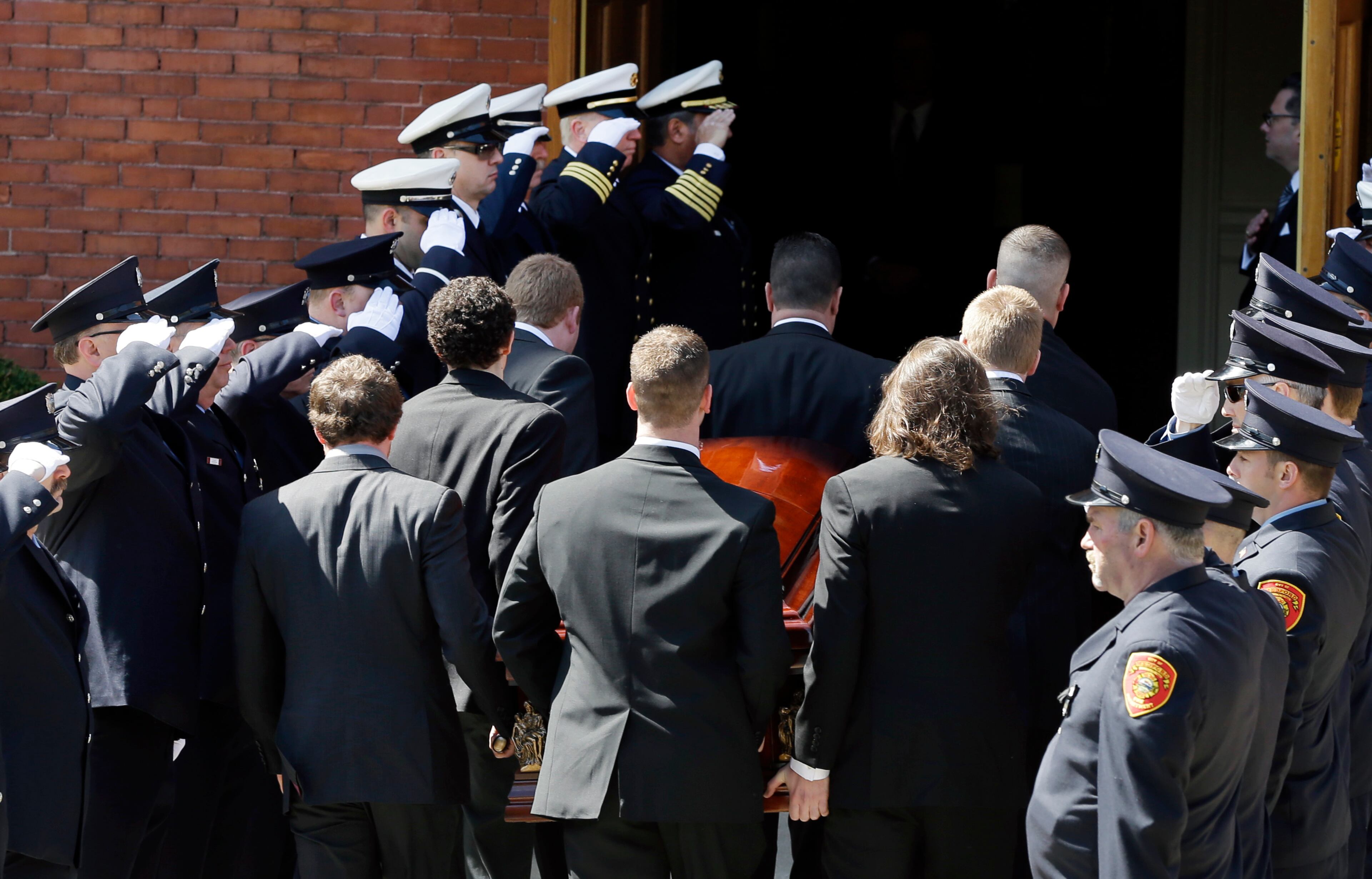 An honor guard from area fire departments salute as pallbearers carry the casket of Boston Marathon bomb victim Krystle Campbell, 29, into St. Joseph's Church for her funeral in Medford, Mass. Monday, April 22, 2013.