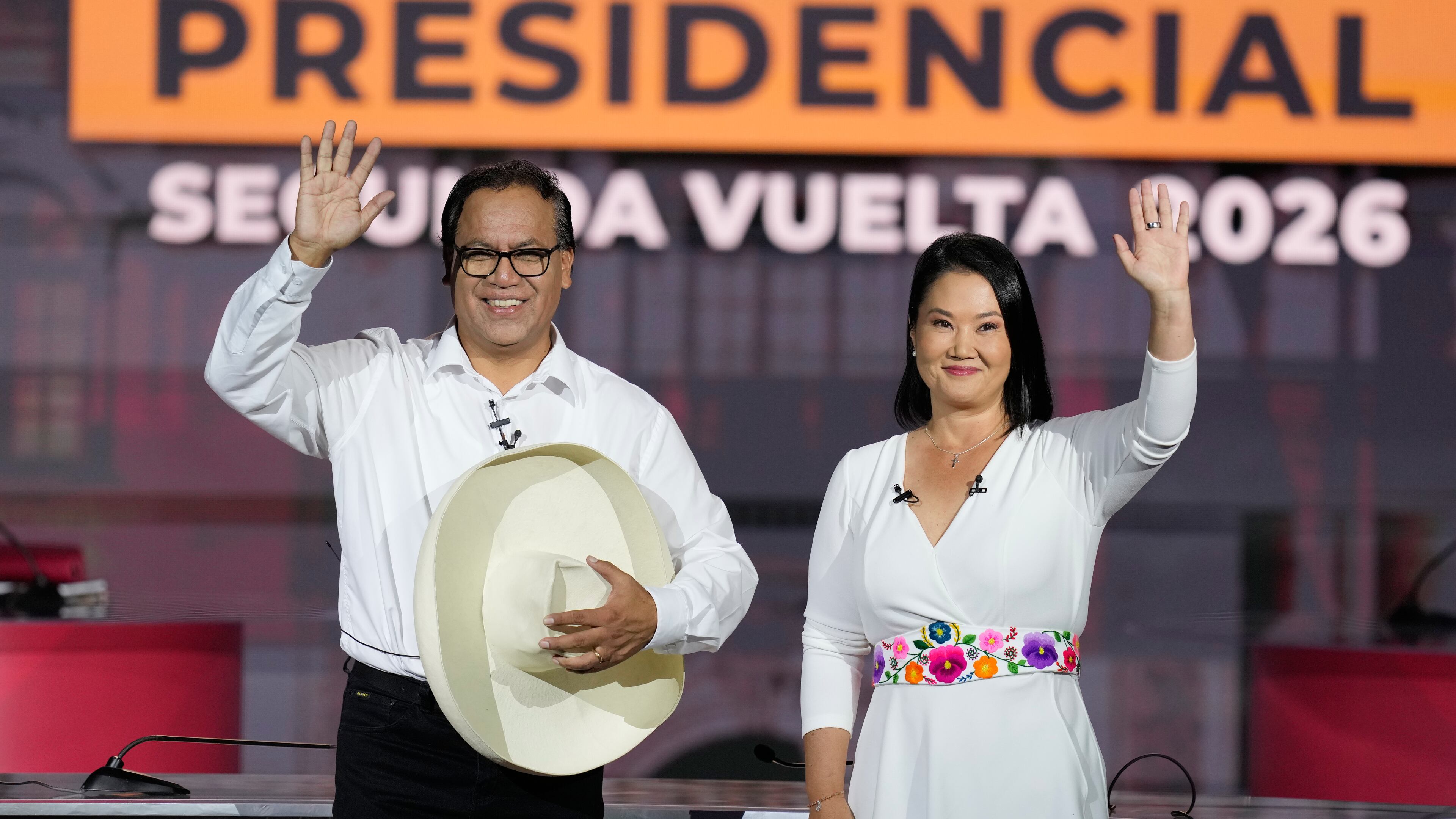 Presidential candidate Keiko Fujimori of the Popular Force party and her rival Roberto Sanchez of Together for Peru party wave during a presidential debate, in Lima, Peru, Sunday, May 31, 2026. (AP Photo/Martin Mejia)