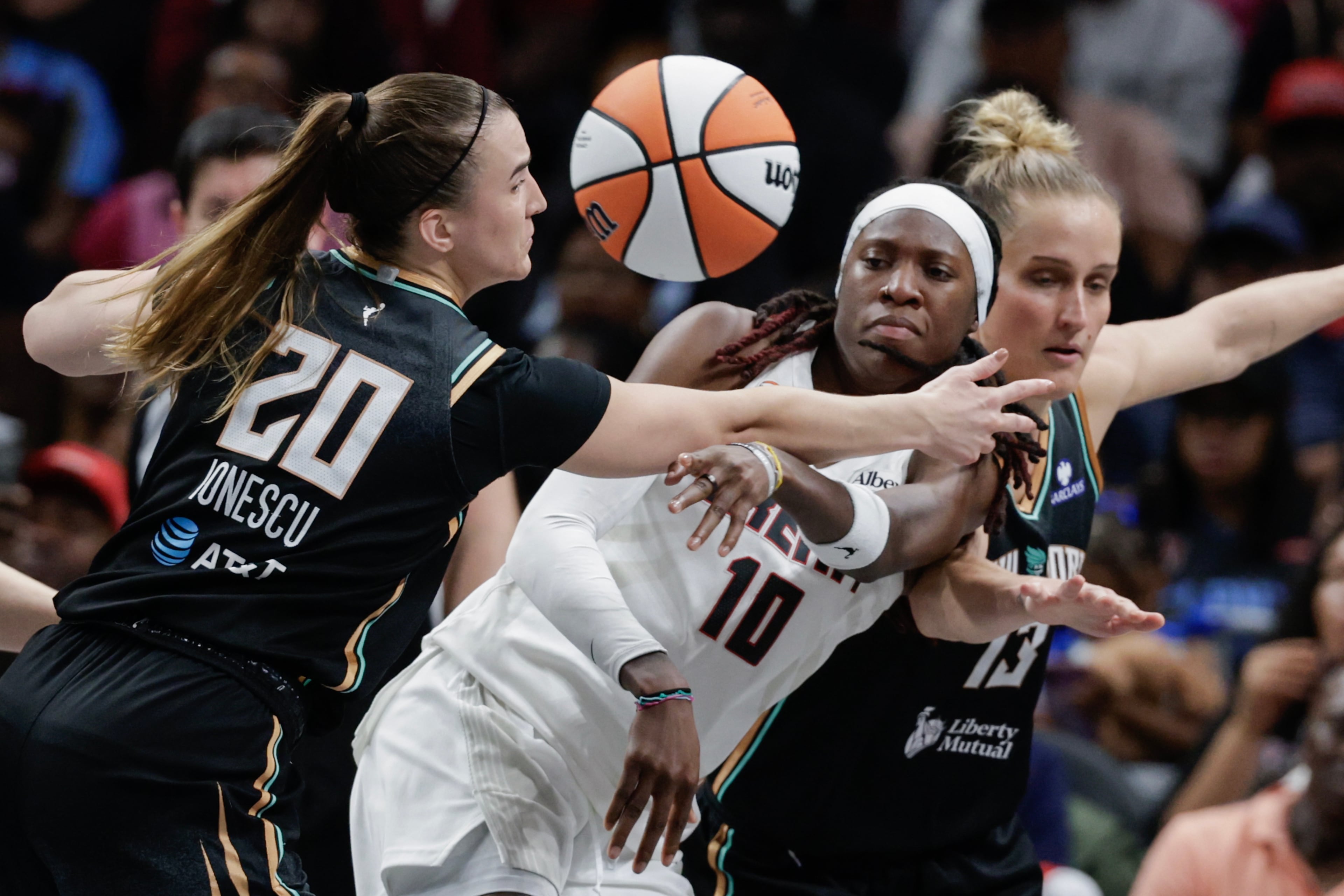 Atlanta Dream guard Rhyne Howard (10) passes against New York Liberty guard Sabrina Ionescu (20) and forward Leonie Fiebich (13) during the second half of a WNBA semifinal playoff game 1 between the Atlanta Dream and the New York Liberty, Sunday, Oct. 4, 2026, in Atlanta. (Erik S. Lesser for the AJC)