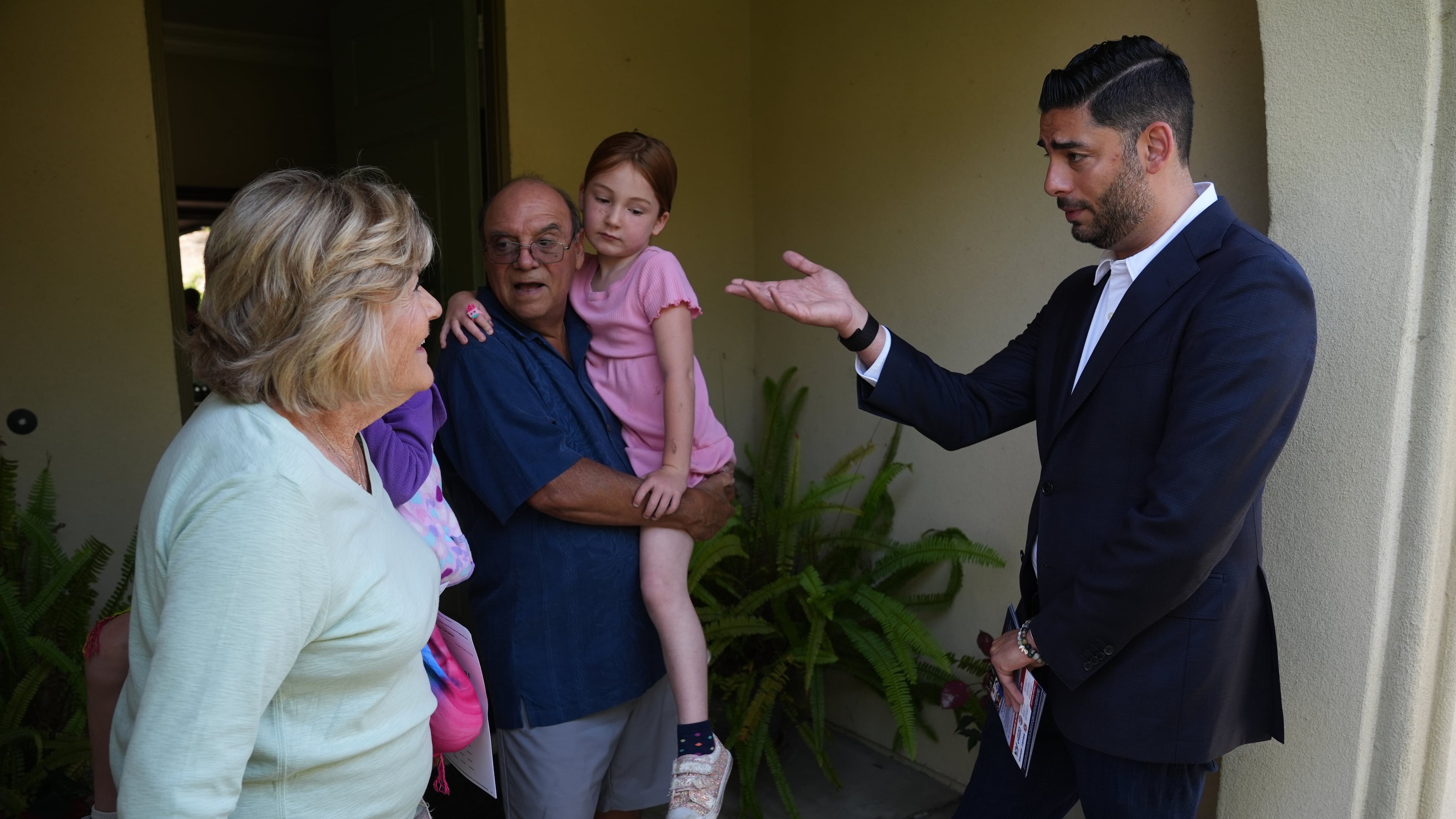 Ammar Campa-Najjar, right, a Democratic candidate for California's 48th Congressional District, speaks with a family as he canvasses in a neighborhood Saturday, May 23, 2026, in San Marcos, Calif. (AP Photo/Gregory Bull)