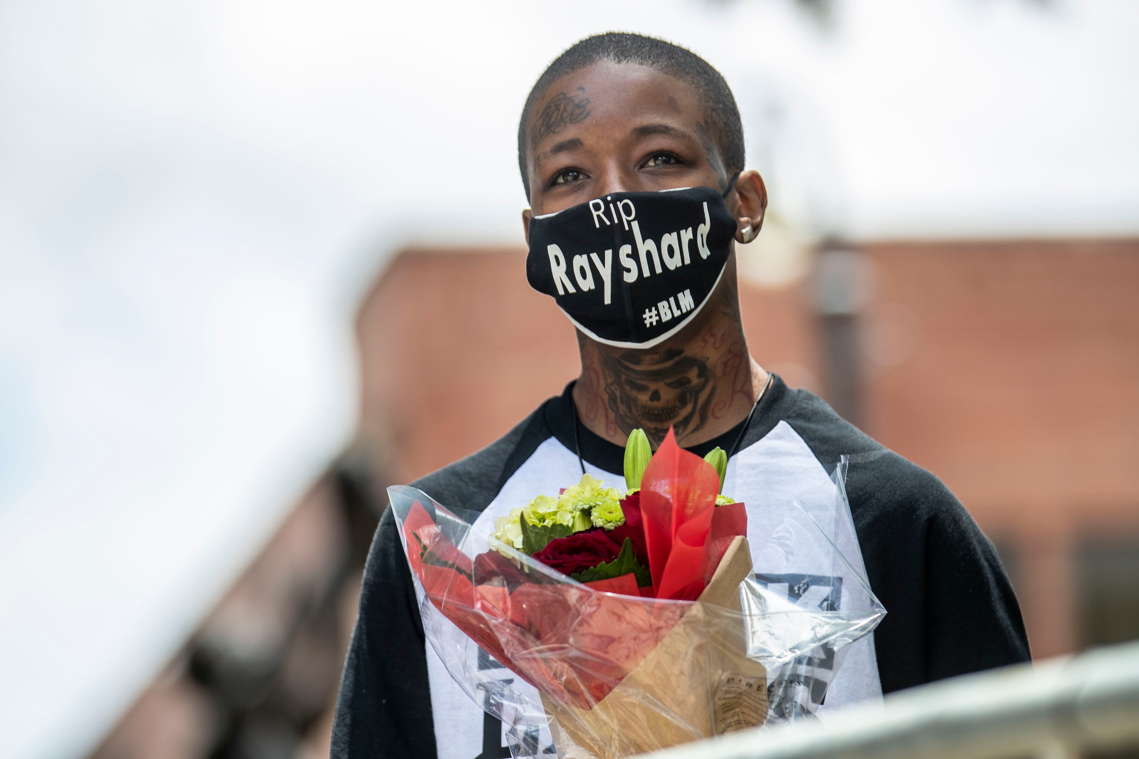 06/23/2020 - Atlanta, Georgia - Latifah Quick holds a bouquet of flowers she hopes to give to Rayshard Brooks' widow, Tomika Miller, while watching the funeral service outside of Ebenezer Baptist Church in Atlanta's Sweet Auburn community, Tuesday, June 23, 2020. Quick says the father of her child was friends with Rayshard Brooks. (ALYSSA POINTER / ALYSSA.POINTER@AJC.COM)