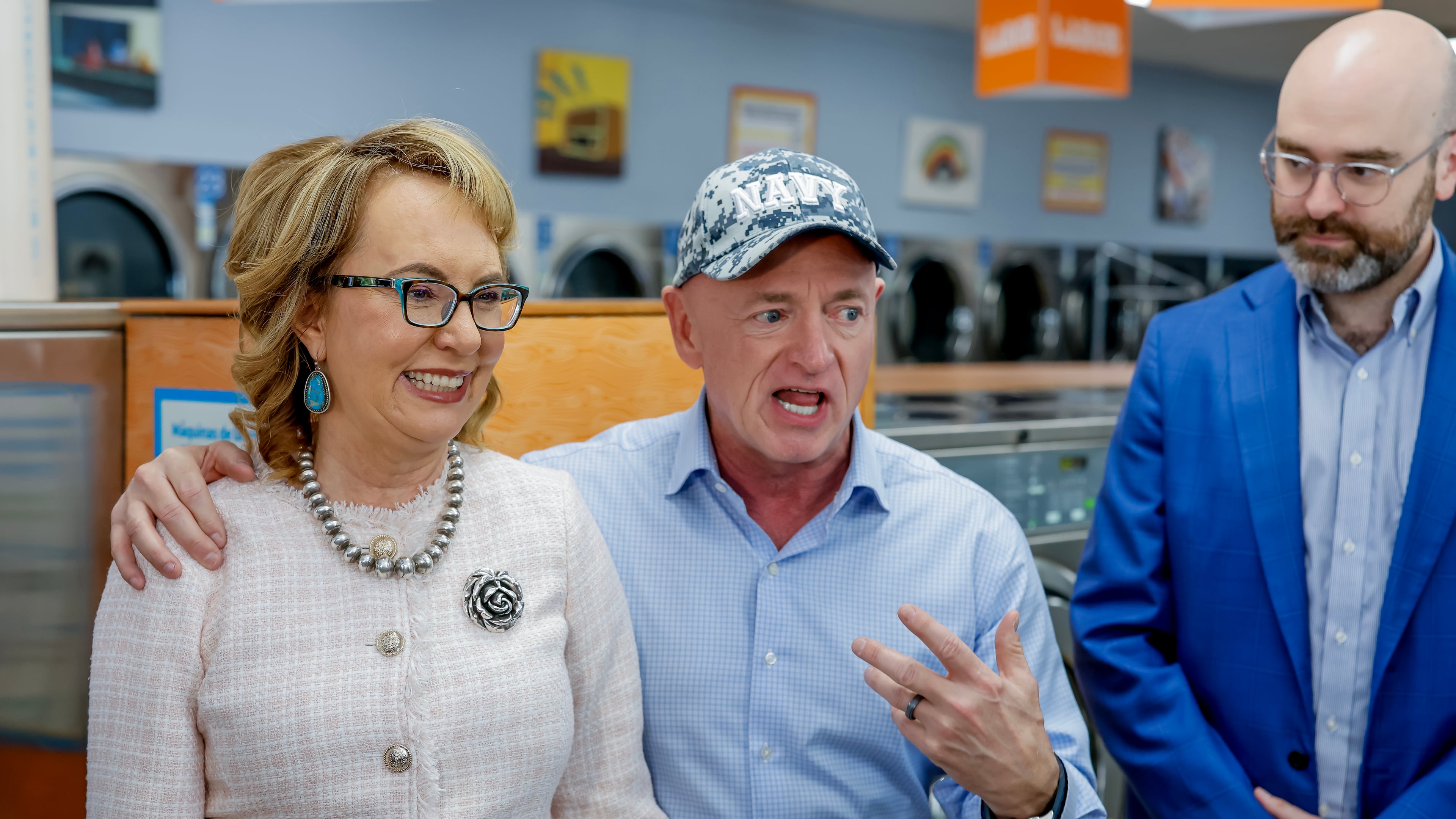 Former Arizona U.S. Rep. Gabby Giffords (left) and her husband, U.S. Sen. Mark Kelly (center), meet with Democratic lieutenant governor nominee Josh McLaurin and others during a campaign stop at the Laundry Lounge in Sandy Springs on Wednesday, Aug. 19, 2026. (Erik S. Lesser for the AJC)