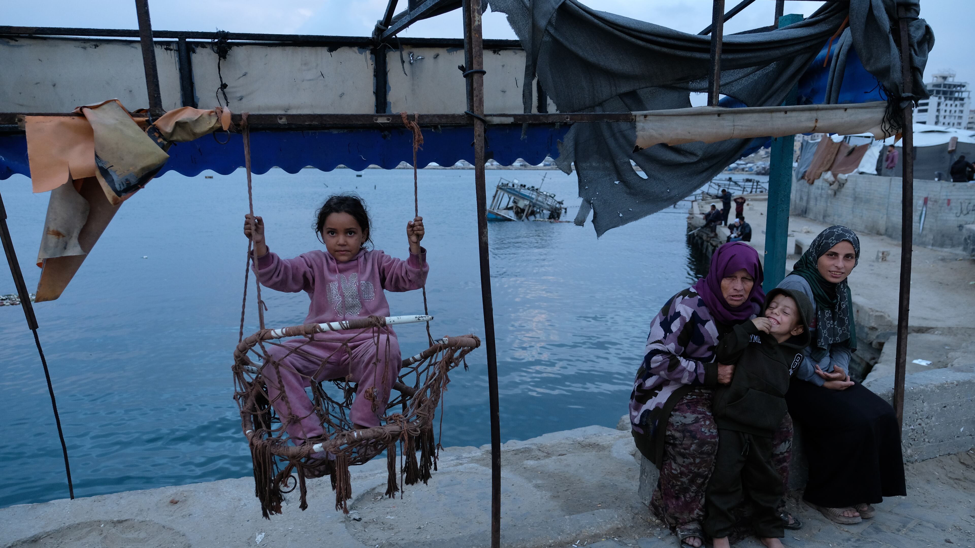 A Palestinian girl sits on a swing in the port of Gaza City on the Mediterranean Sea, Saturday, Dec. 6, 2025. (AP Photo/Jehad Alshrafi)