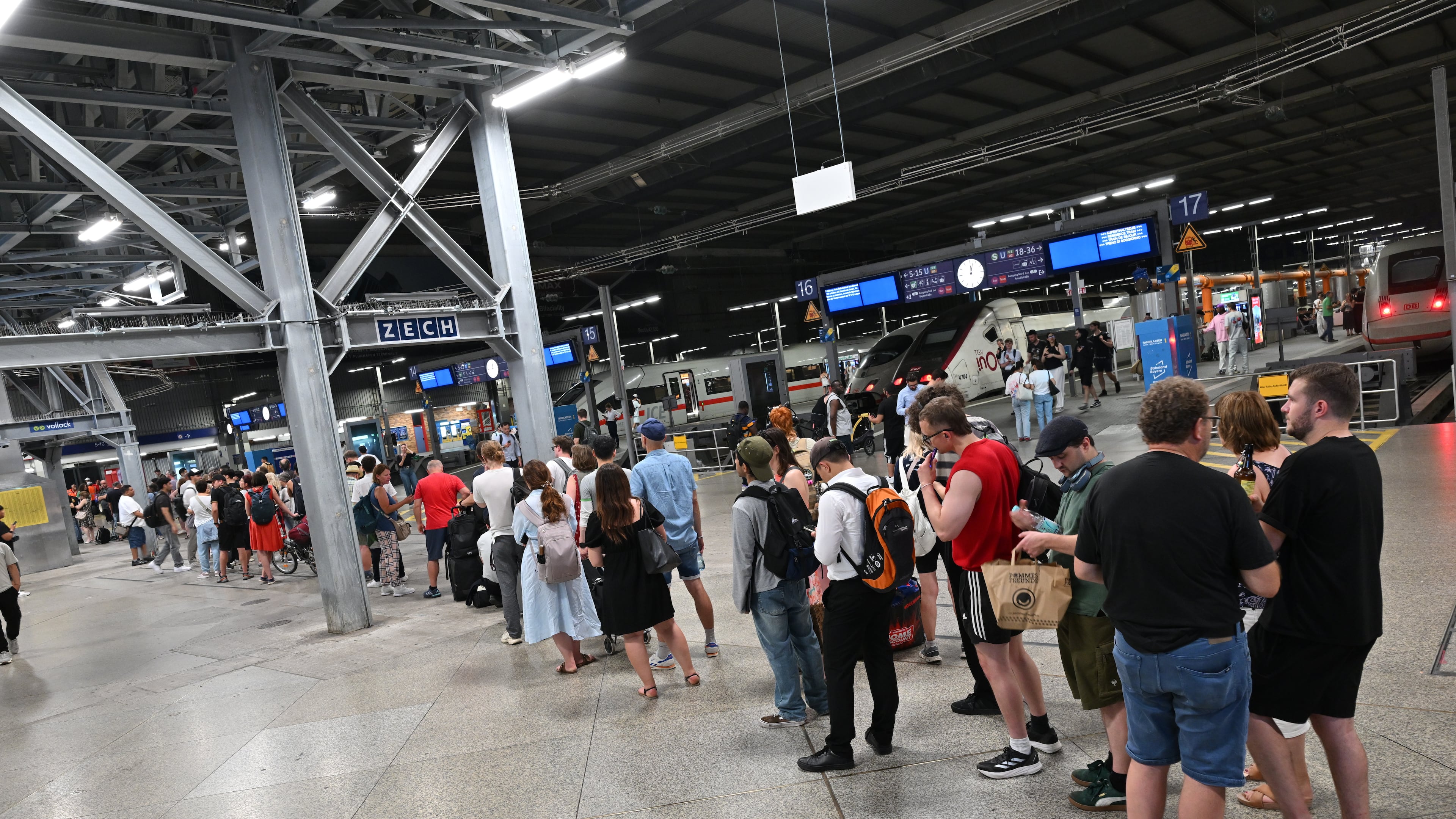 Passengers stand in line at the DB information desk at the Munich train station, Tuesday, June 23, 2026. (Peter Kneffel/dpa via AP)
