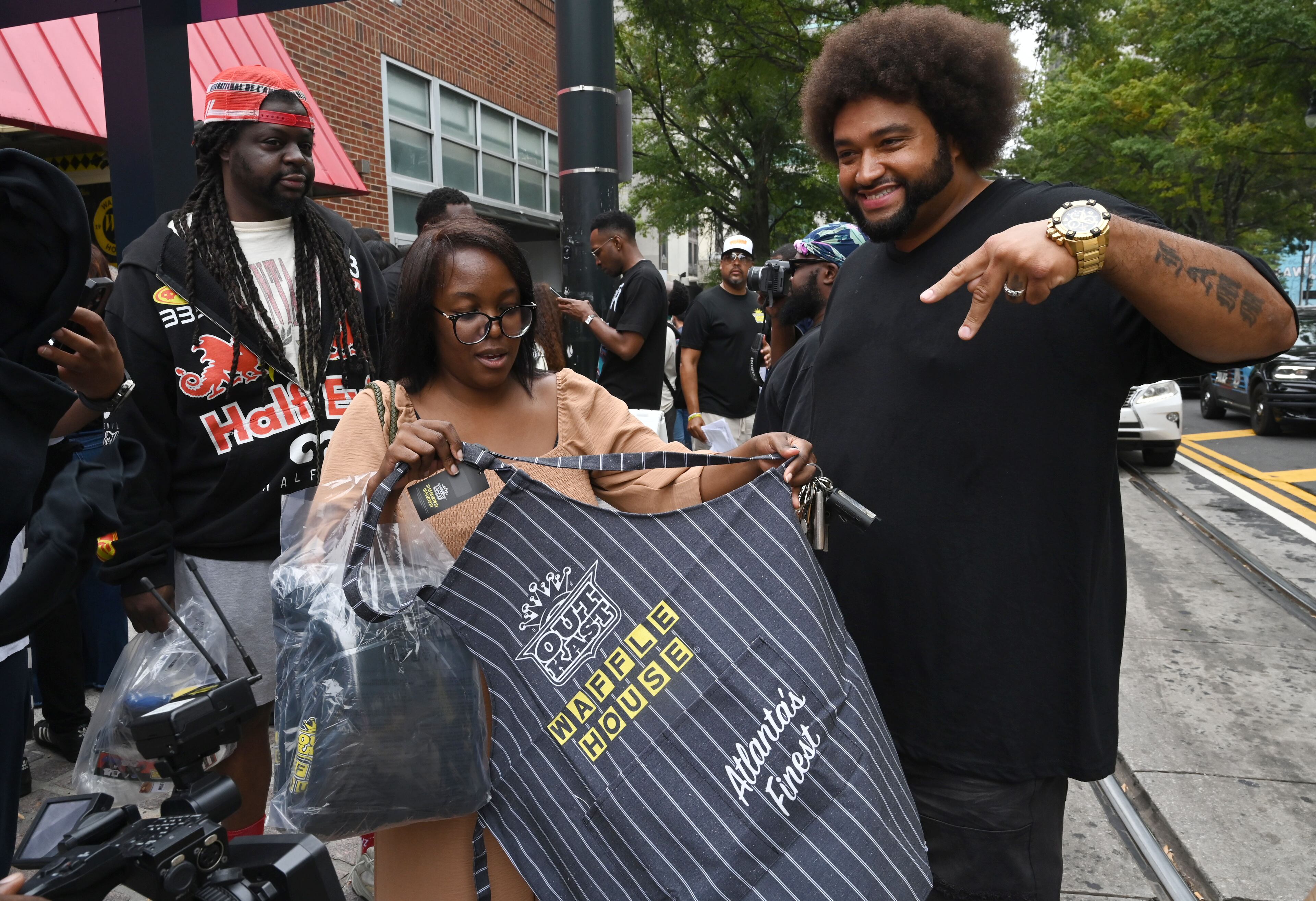 Melanie and John Williams scored an apron and other limited-edition apparel and accessories from the Outkast and Waffle House collaboration. (Hyosub Shin/AJC)