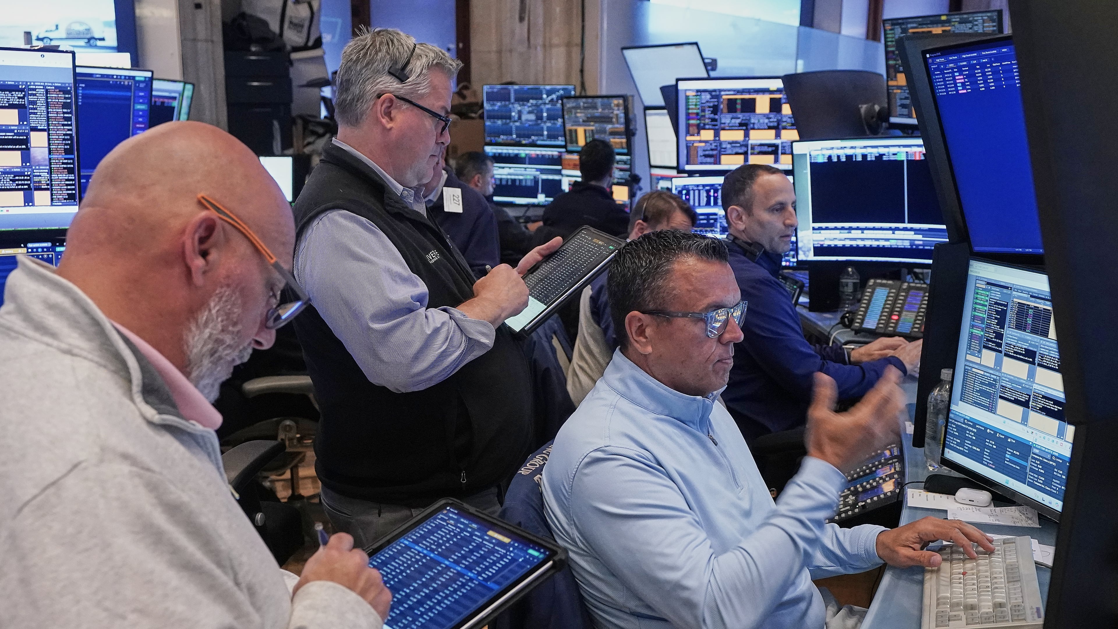 Robert Finnerty, Jr., foreground right, works with colleagues on the floor of the New York Stock Exchange, Thursday, May 7, 2026. (AP Photo/Richard Drew)