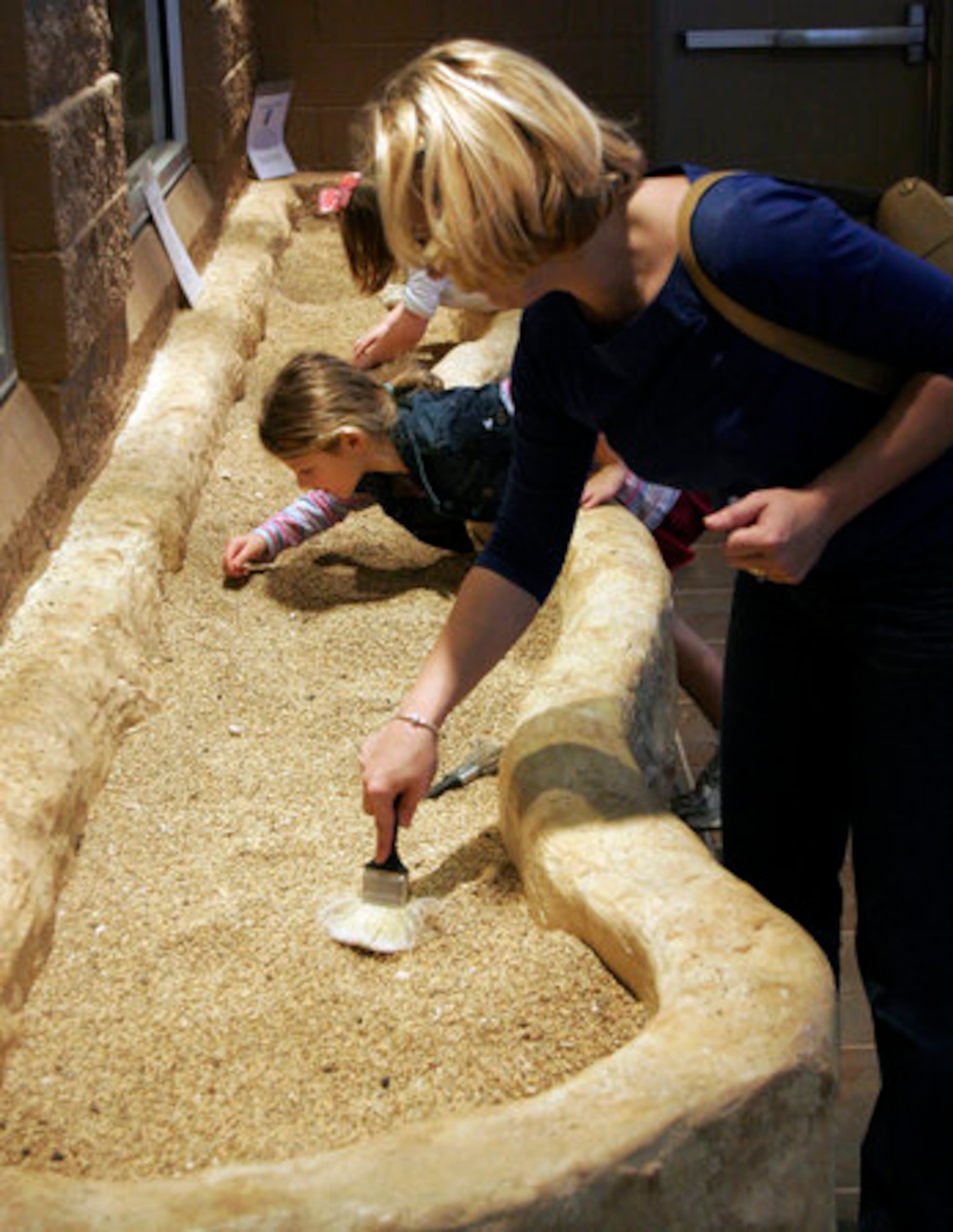 AT CARTERSVILLE'S new Tellus Northwest Georgia Science Museum, digging in the dirt is encouraged. You might find a fossil or a mineral. Here, Jennifer Chandler and daughter Haley at work.