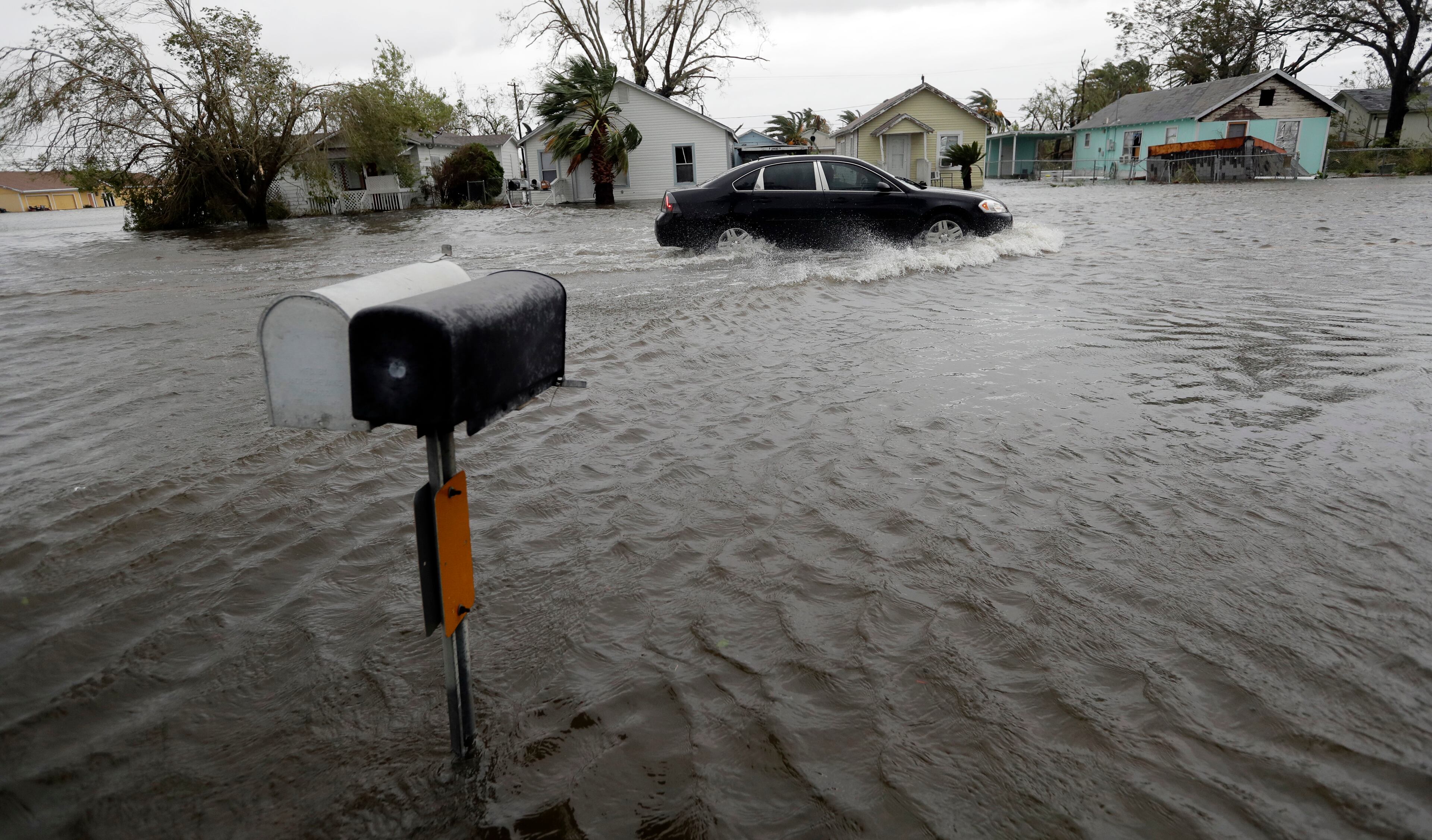 A drives moves through flood waters left behind by Hurricane Harvey, Saturday, Aug. 26, 2017, in Aransas Pass, Texas. Harvey rolled over the Texas Gulf Coast on Saturday, smashing homes and businesses and lashing the shore with wind and rain so intense that drivers were forced off the road because they could not see in front of them. (AP Photo/Eric Gay)