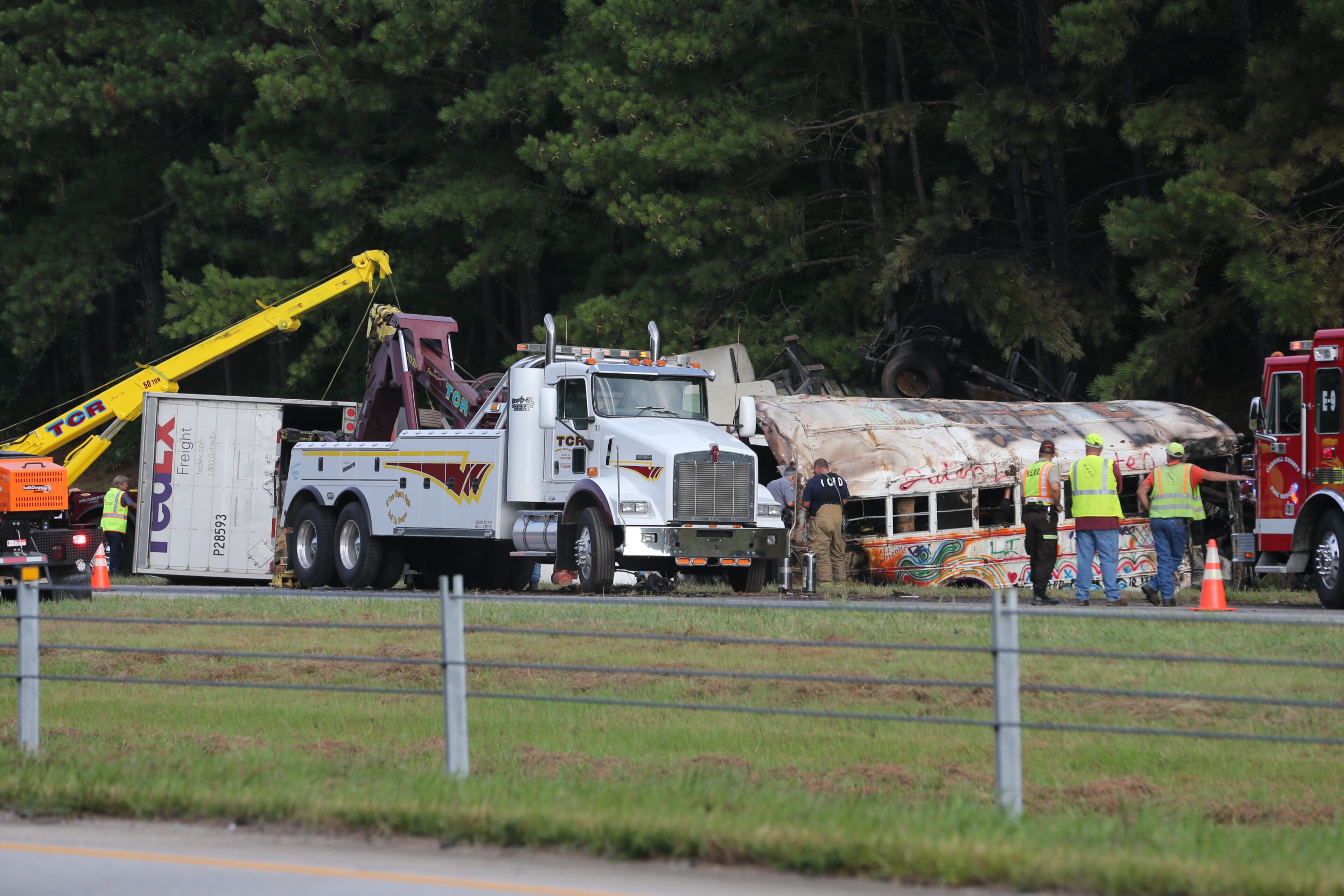 “Initial indications are that it’s a tractor-trailer and some type of bus,” the Georgia State Patrol said in an email. A FedEx truck with tandem trailers was overturned on the right side of the roadway, and the bus overturned and caught fire along the wood line. JOHN SPINK/JSPINK@AJC.COM