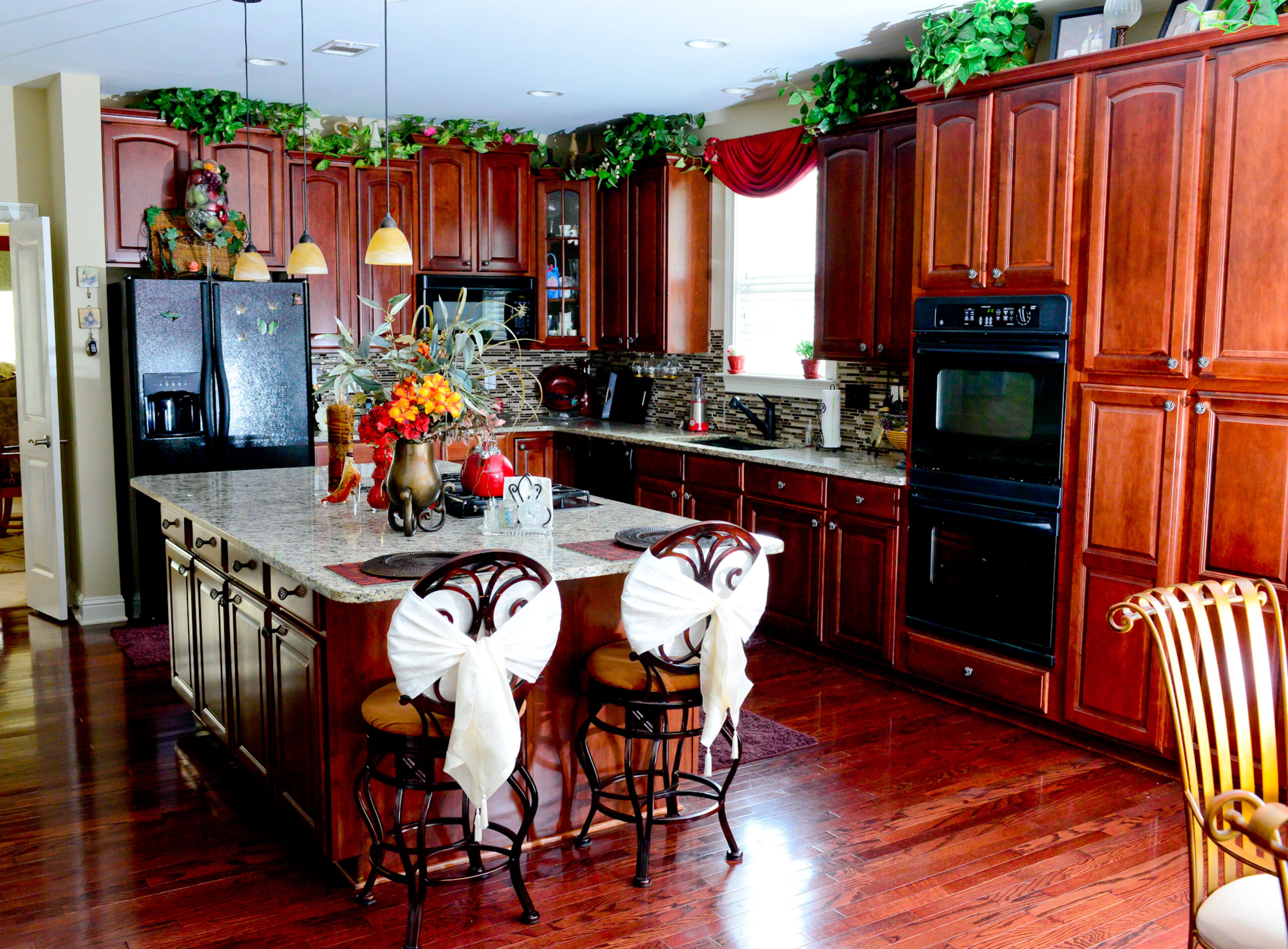 Homeowners Frances and Garnell Pace chose the cherry cabinets and granite countertops while the house was under construction. A floral arrangement from Pier 1 Imports highlights the large island, which provides plenty of room for meals.