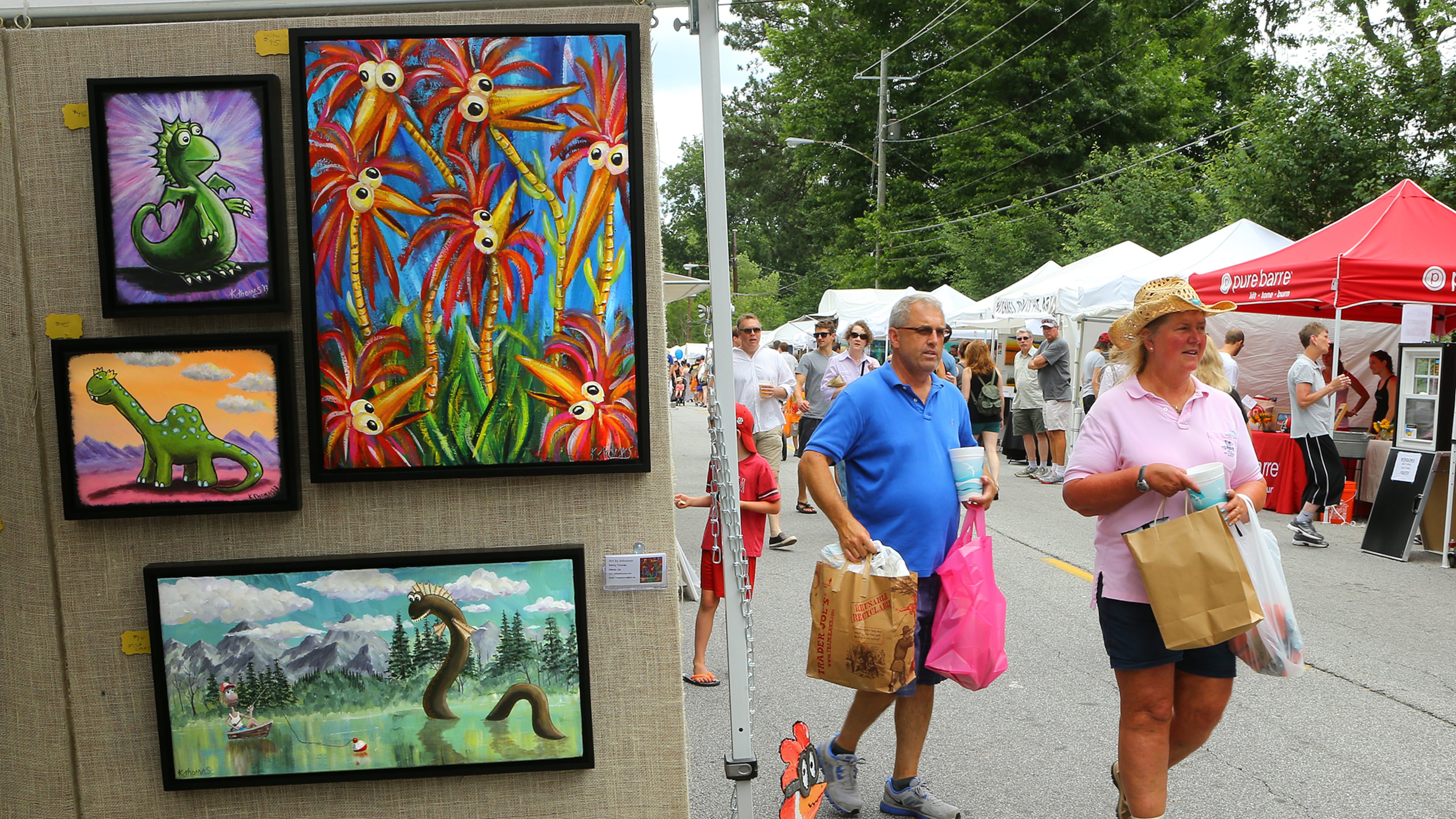 Mandy and Tony Finger, Marietta, pass by some art by Kenny Thomas while shopping the booths during the Virginia-Highland Summerfest 2014. CURTIS COMPTON / CCOMPTON@AJC.COM