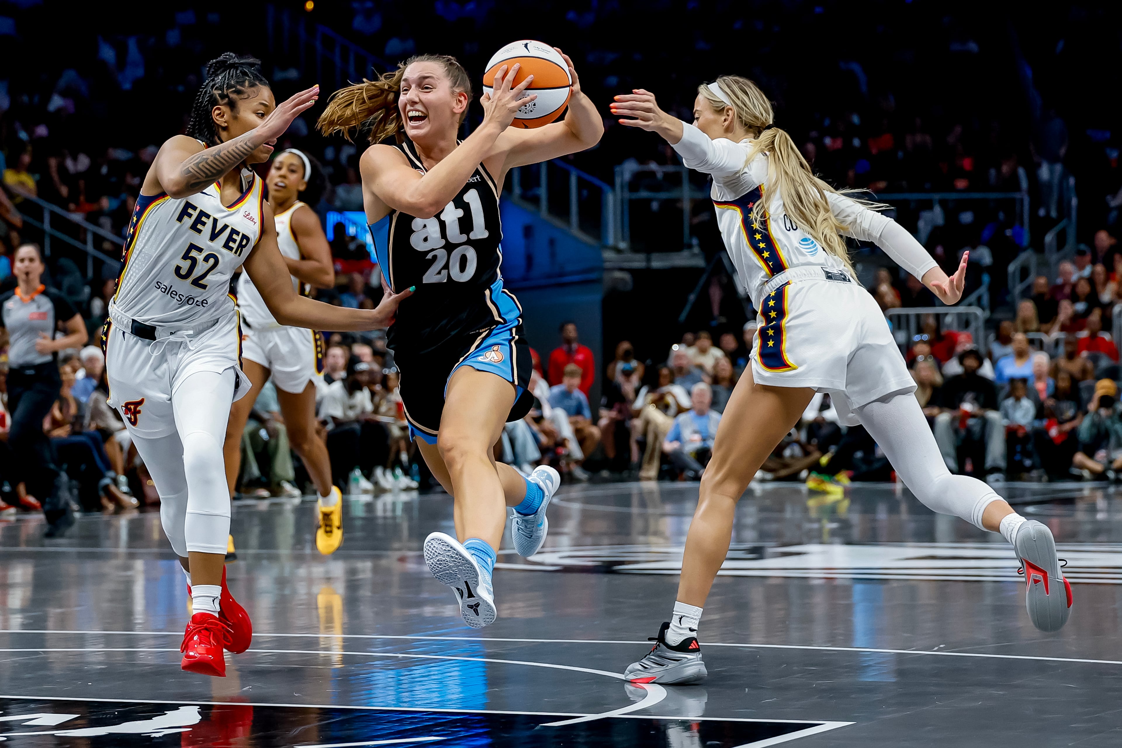 Atlanta Dream guard Isobel Borlase (center) drives against Indiana Fever guards Tyasha Harris (left) and Sophie Cunningham during a WNBA game between the Atlanta Dream and the Indiana Fever, Sunday, Aug. 16, 2026, in Atlanta. The Dream lost 95-91 in overtime. (Erik S. Lesser for the AJC)