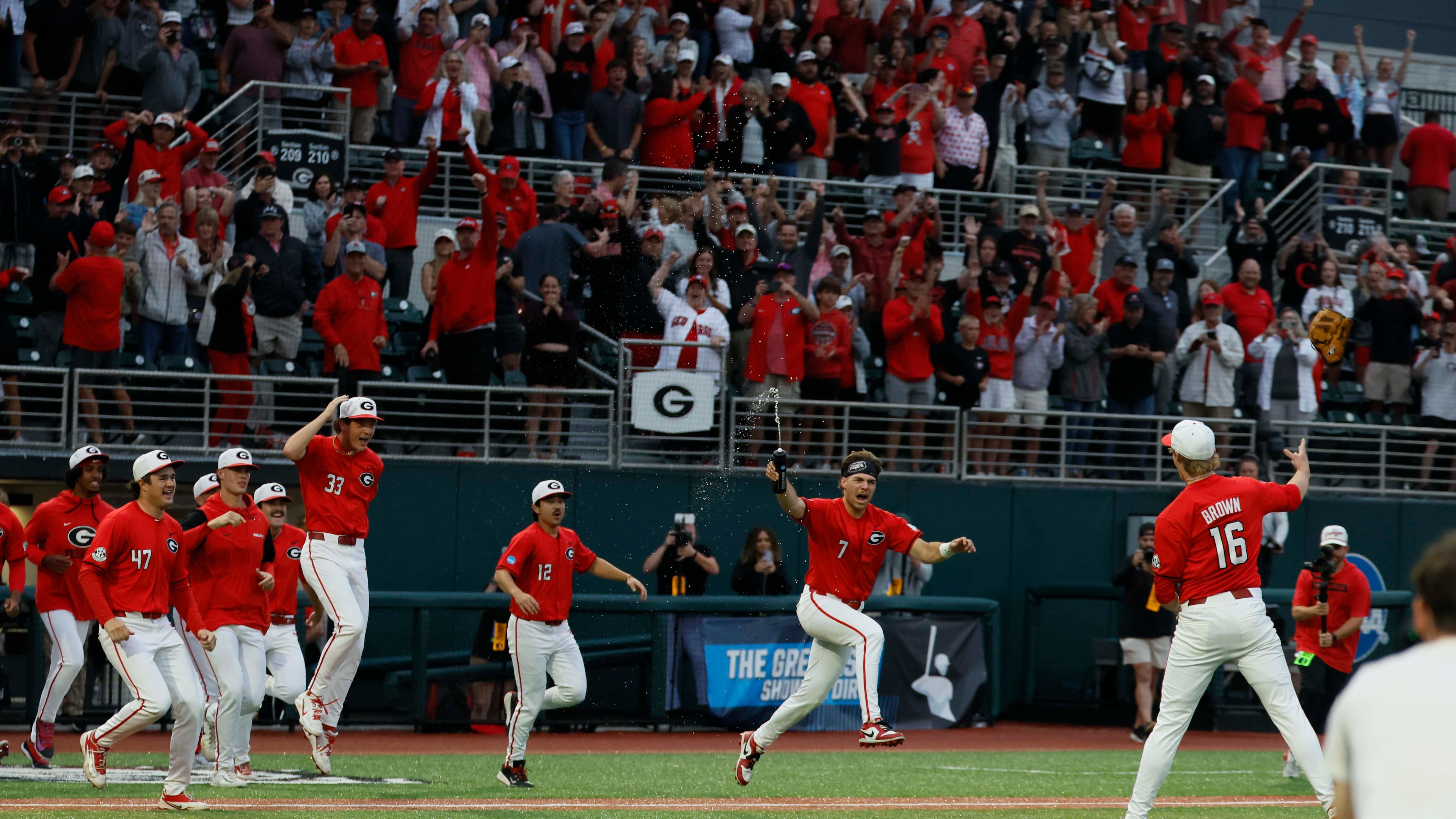 Georgia players rushed to celebrate with pitcher Zach Brown (right) after the team defeated Liberty 6-1 in an NCAA Regional final at Foley Field on Sunday, May 31, 2026, in Athens. (Miguel Martinez/AJC)