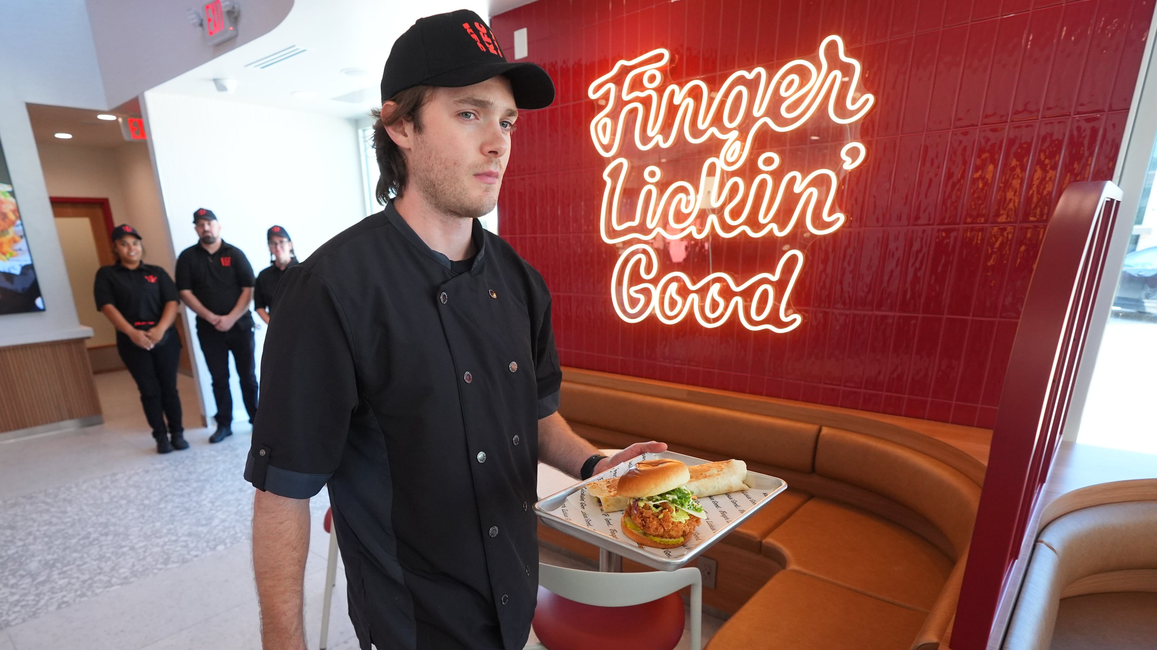 Jacob Mitchell carries a tray of food at new KFC restaurant pre-opening presentation in McKinney, Texas, Tuesday, Sept. 22, 2026. (AP Photo/LM Otero)
