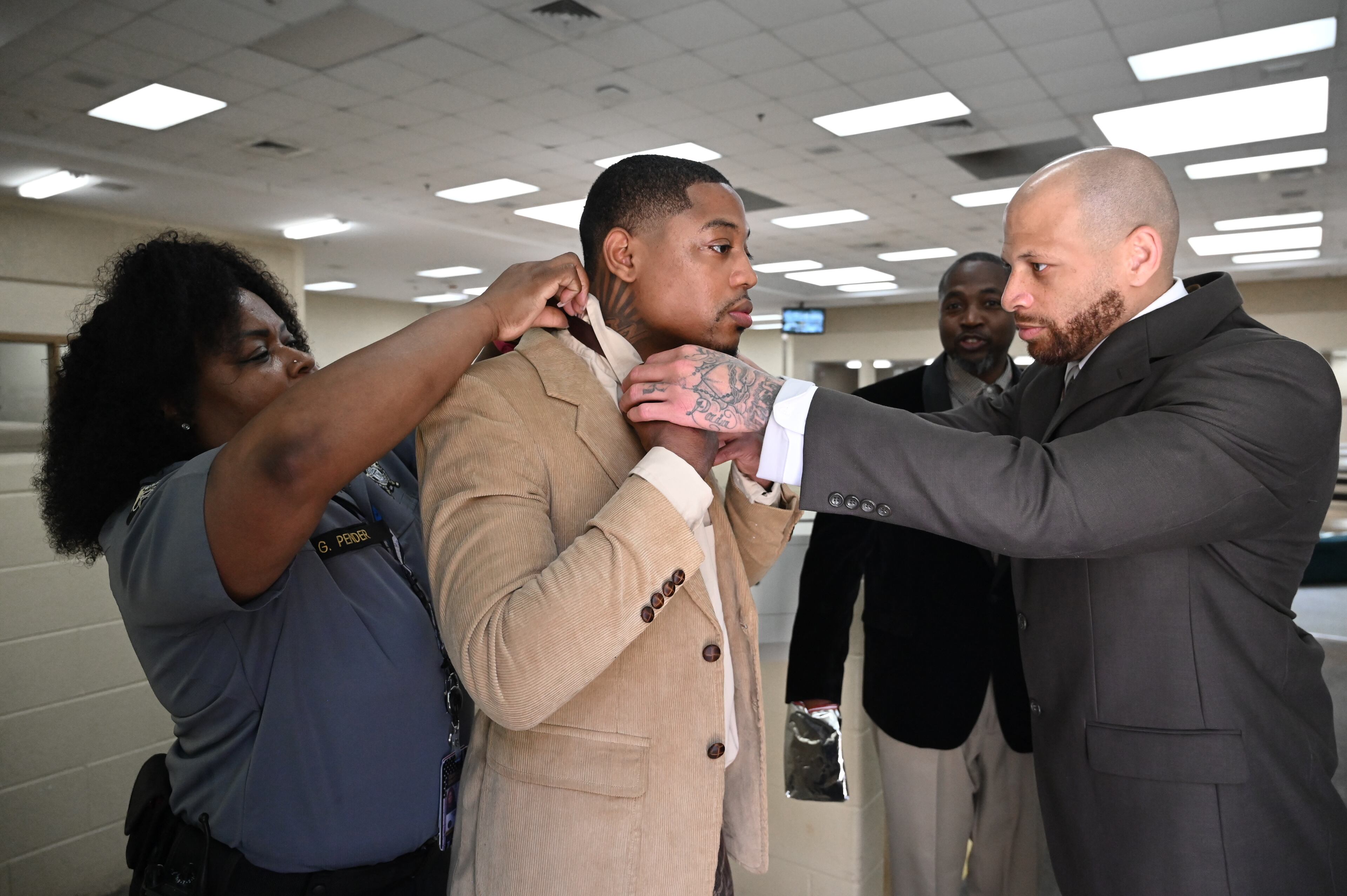 Deputy Gloria Pender (left) and Donovan Mallard help Cornelius Peterson with tying a necktie before their graduation ceremony for the Re-Entry Success Program at the Athens-Clarke County Jail on Wednesday, June 18, 2025, in Athens. (Hyosub Shin/AJC)
