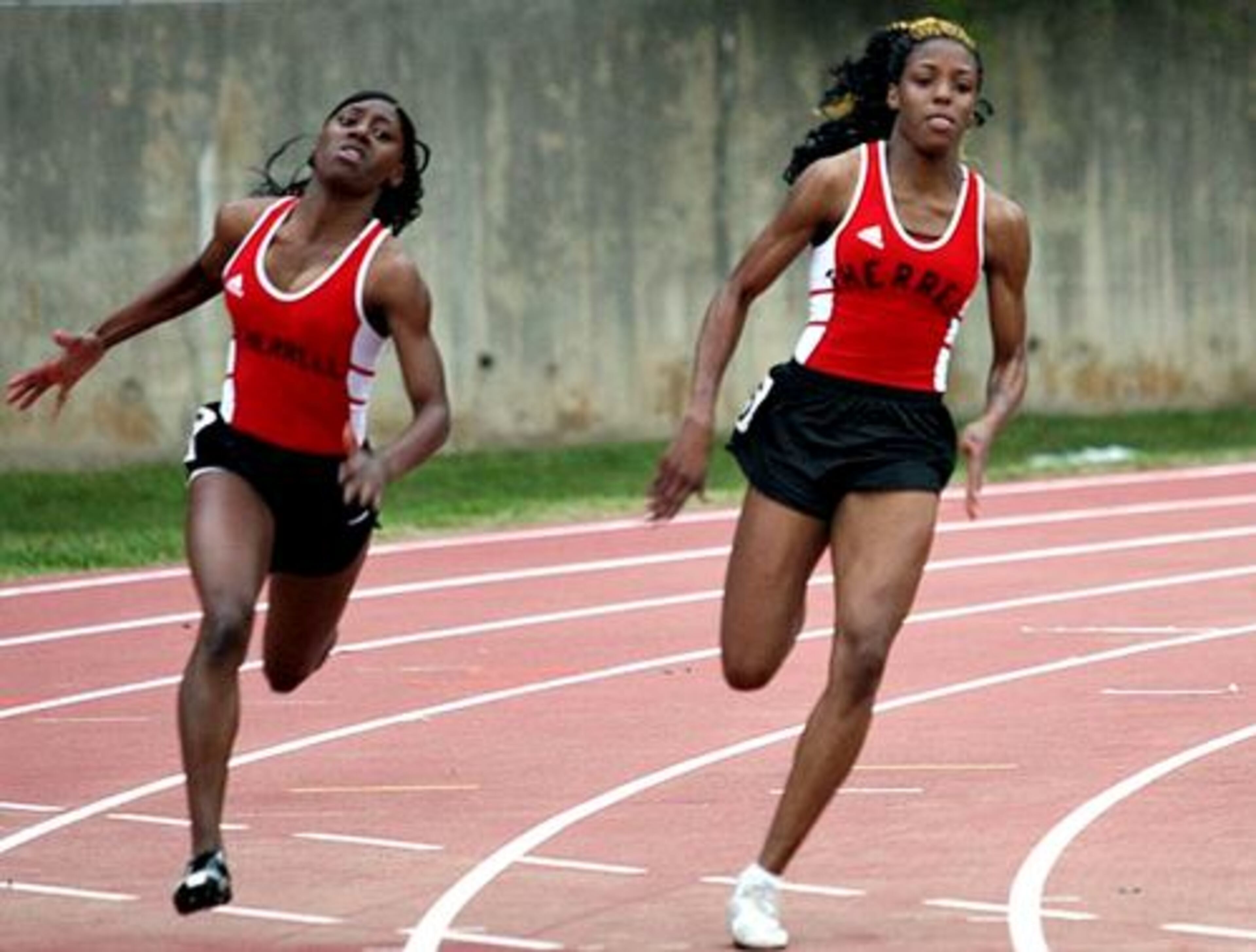 Therrell's Brittany Long (right) moves past teammate Jawanda King in the turn during the Girls' 200 Meter Dash.