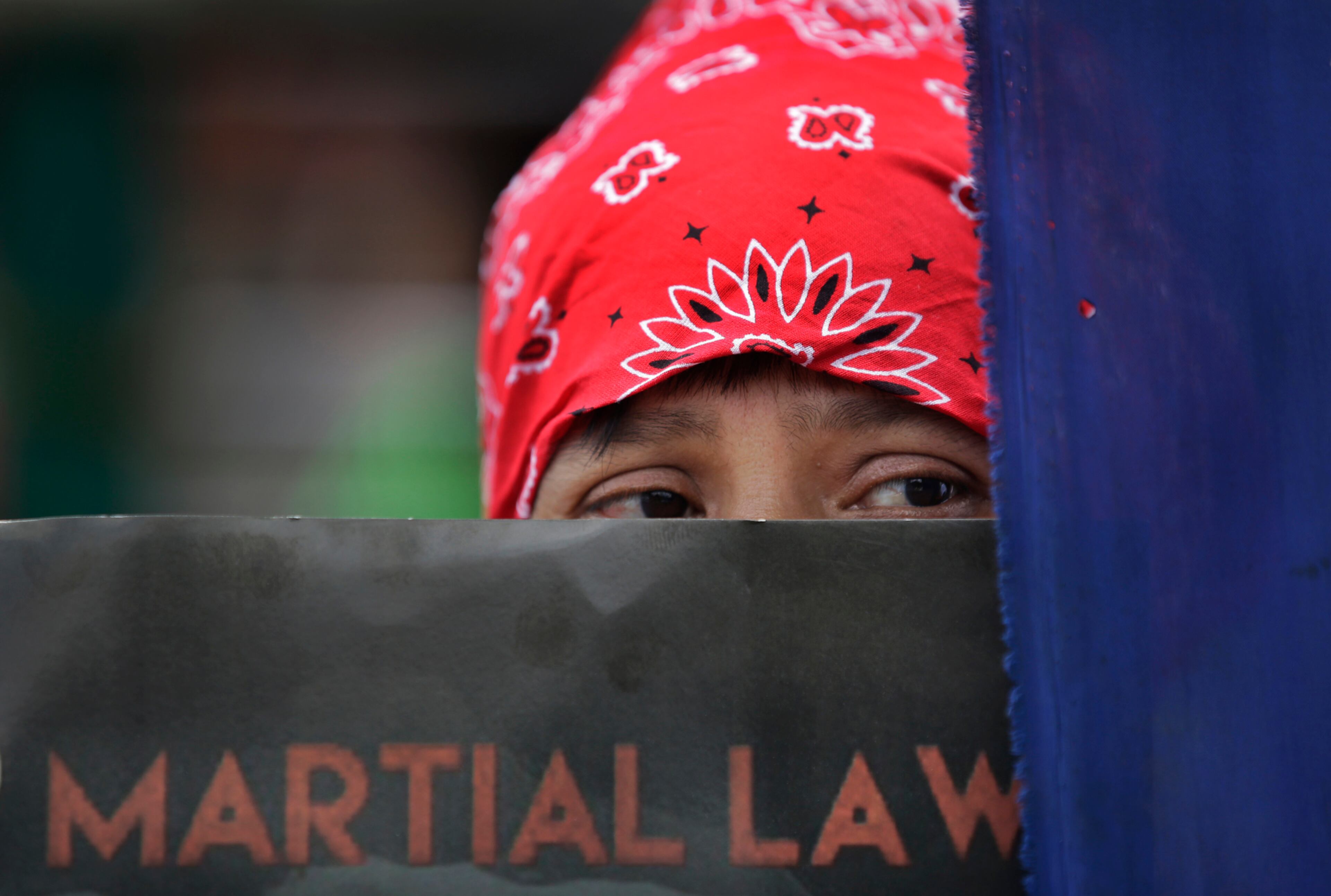 An activist holds a placard denouncing martial law during a rally, Wednesday, July 5, 2017, in Manila, Philippines. The Philippine Supreme Court recently upheld the president's declaration of martial law in the south in a legal boost to the military's offensive that officials say may soon succeed in quelling an uprising by Islamic State group-linked militants. (AP Photo/Aaron Favila)
