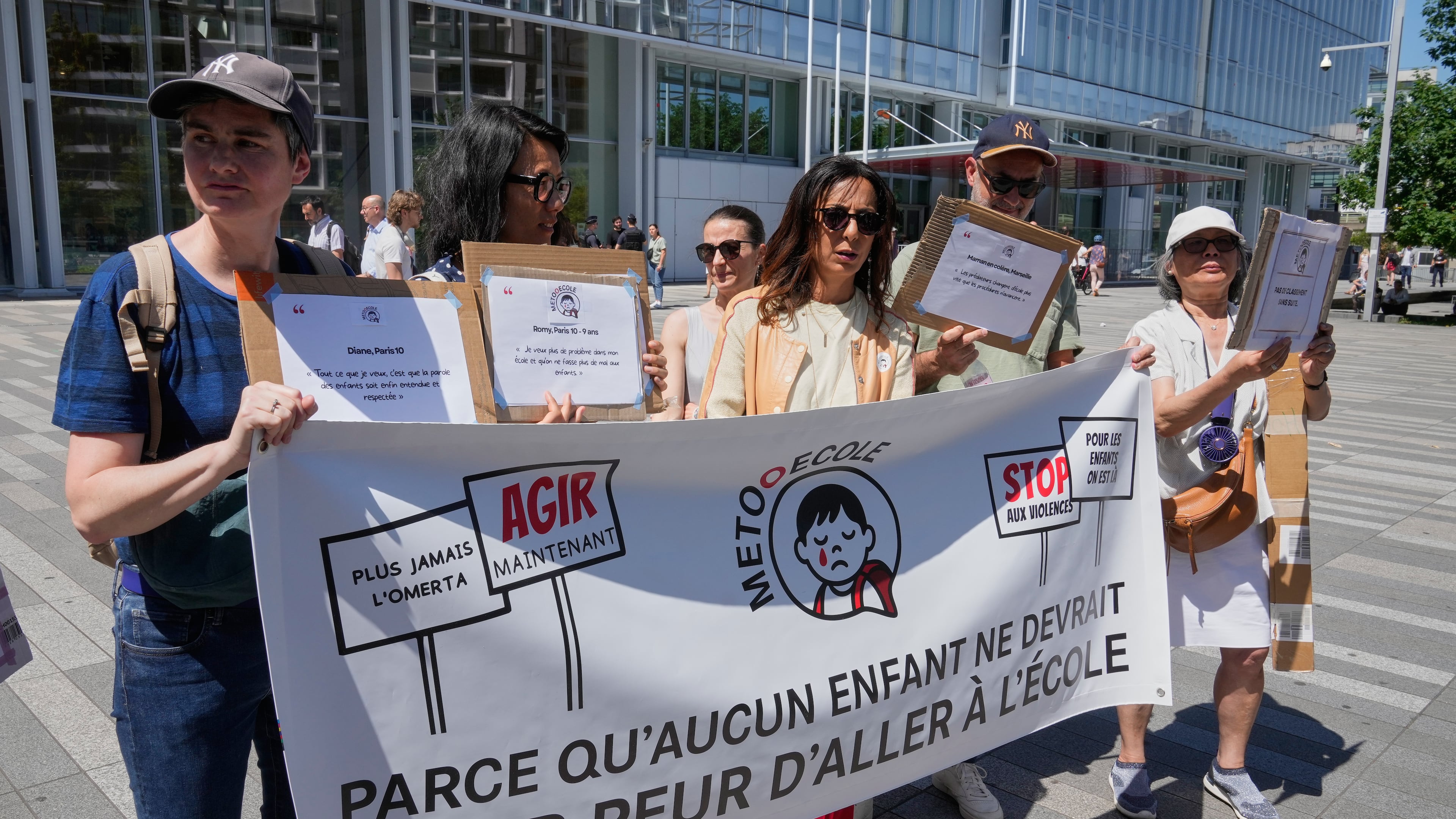 Members and supporters of the #METooEcole (#METooSchool) movement stage a protest to draw attention to a child abuse scandal in France in front of the courthouse in Paris on Tuesday May 26, 2026. The banner reads, in French, "Because no child should ever be afraid to go to school." (AP Photo/Michel Euler)