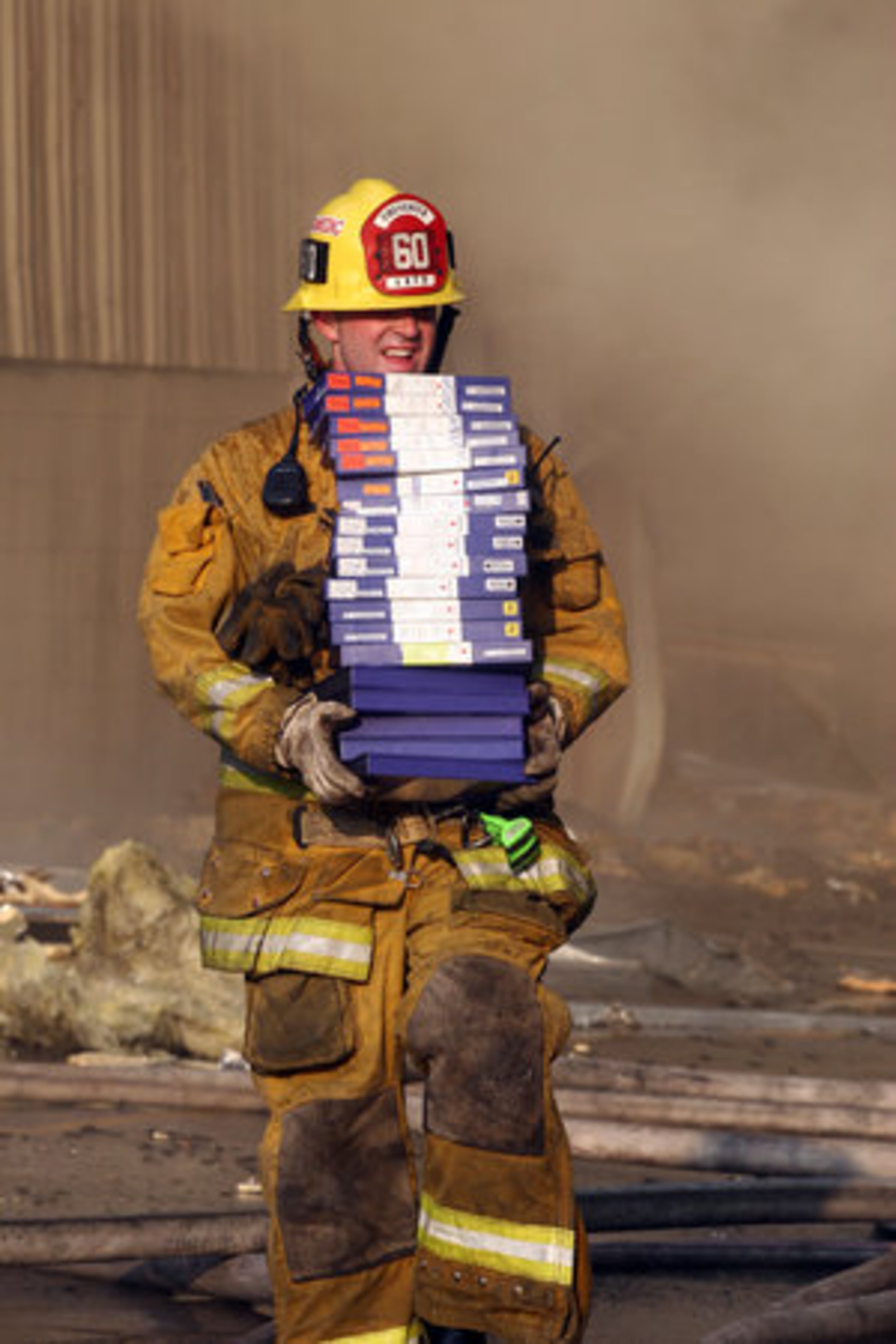 A firefighter removes videotapes from a burning video vault Sunday.