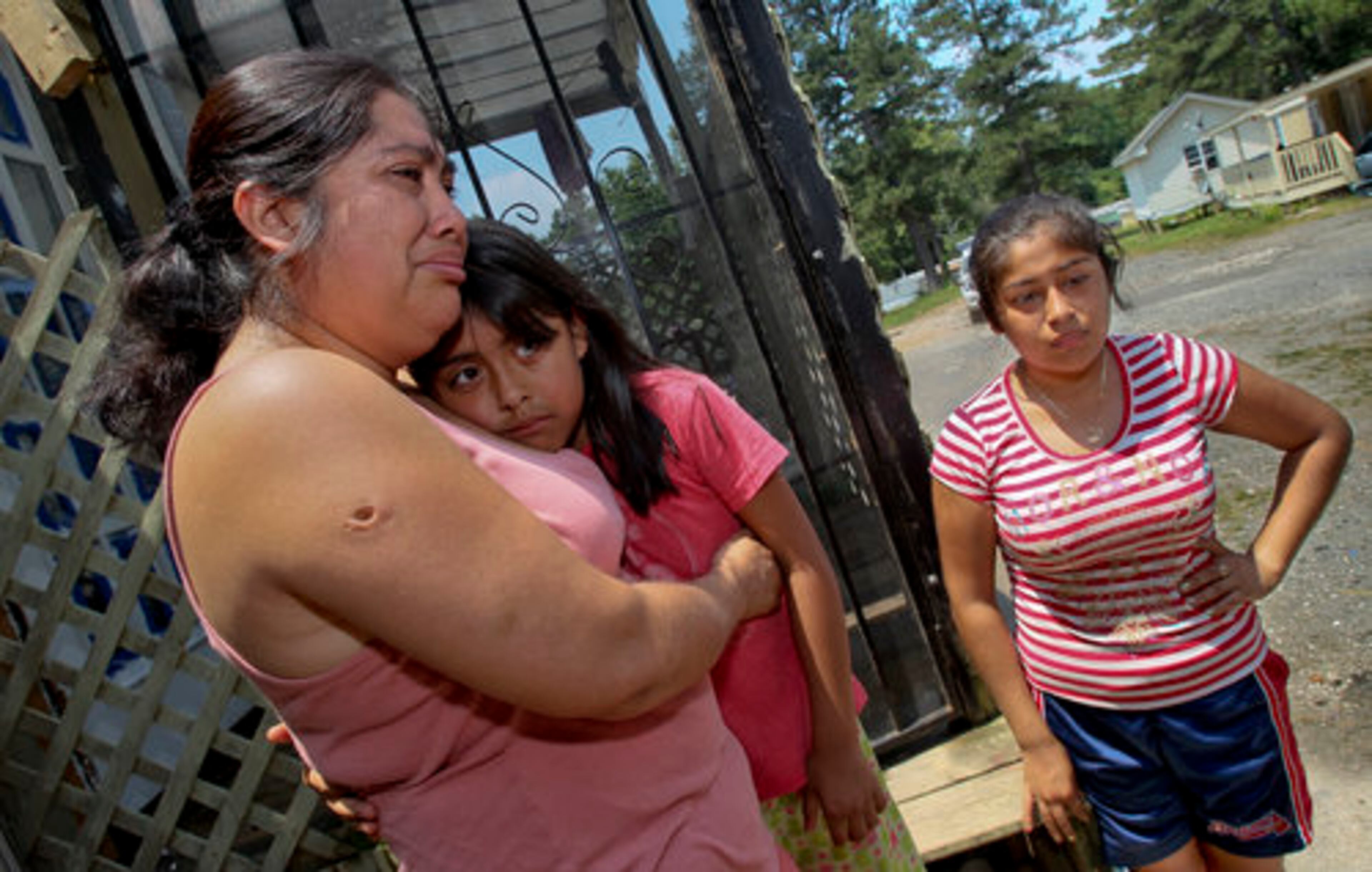 Neighbor Emily Campos (left) with daughters Ashley Ramos, 8, and daughter, Sherly Parada, 15, reflect on the death of Javier Mondragon.