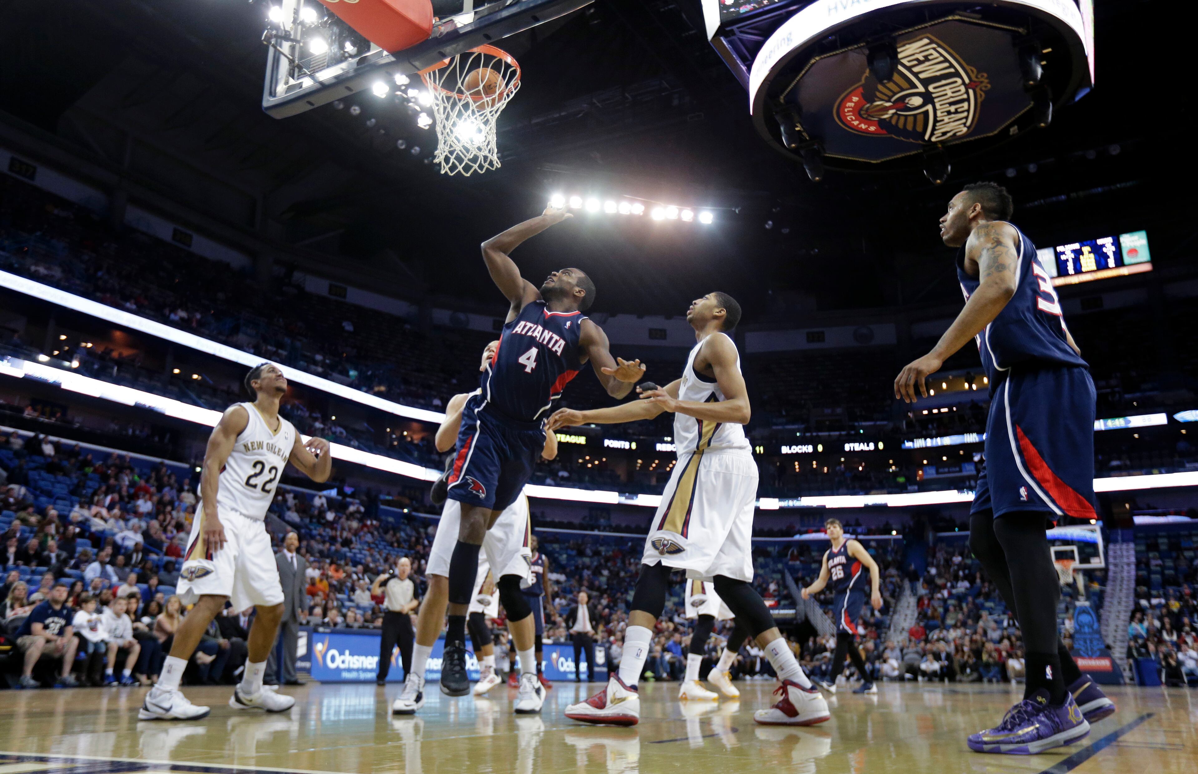 Hawks power forward Paul Millsap (4) goes to the basket between New Orleans Pelicans power forward Anthony Davis, right, and point guard Brian Roberts (22).