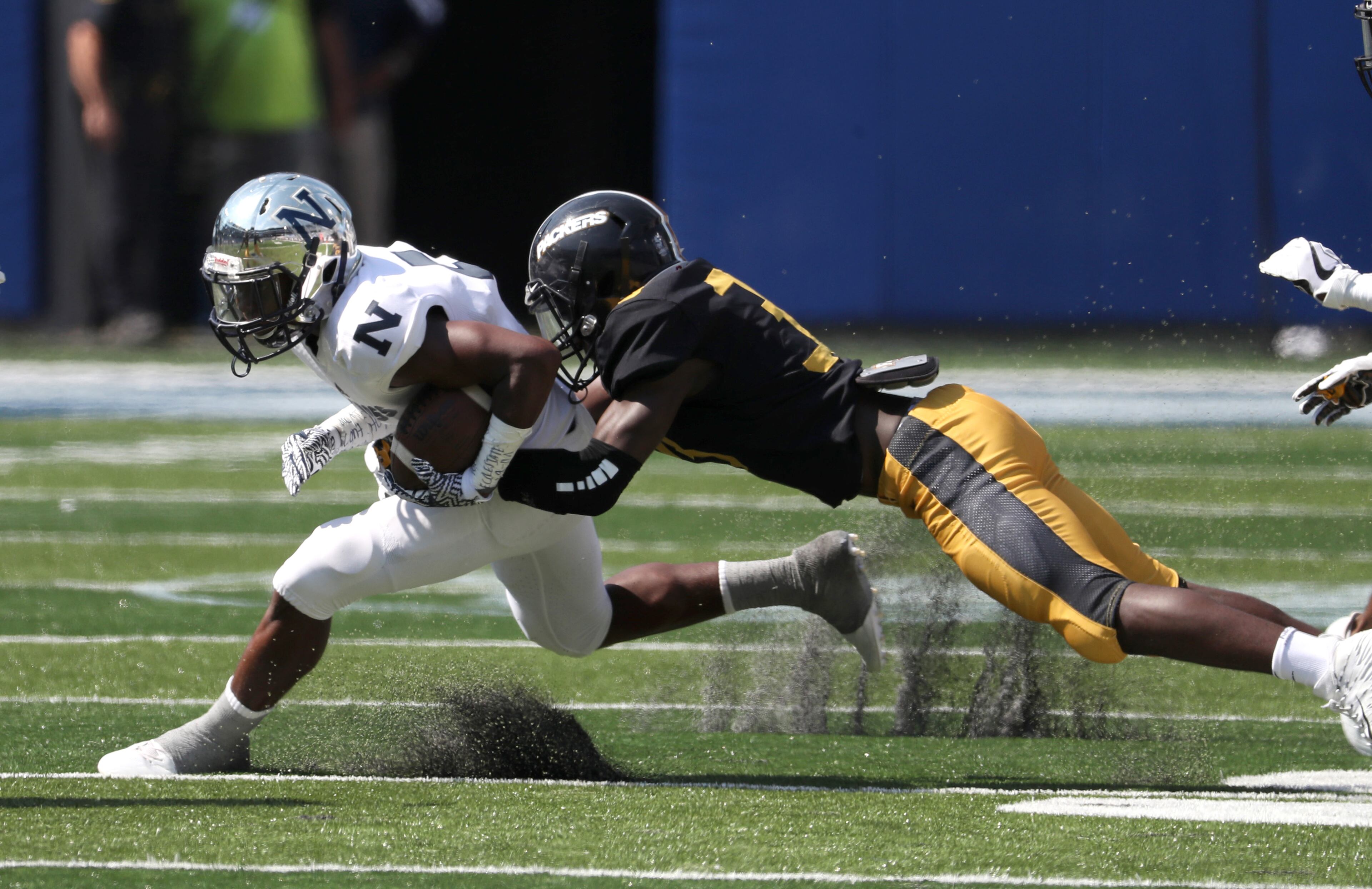 Norcross running back Dohnte Meyers (5) is tackled after a run by Colquitt County safety Dante Moore (33) during the Corky Kell Classic at Georgia State Stadium Saturday, August 19, 2017, in Atlanta.