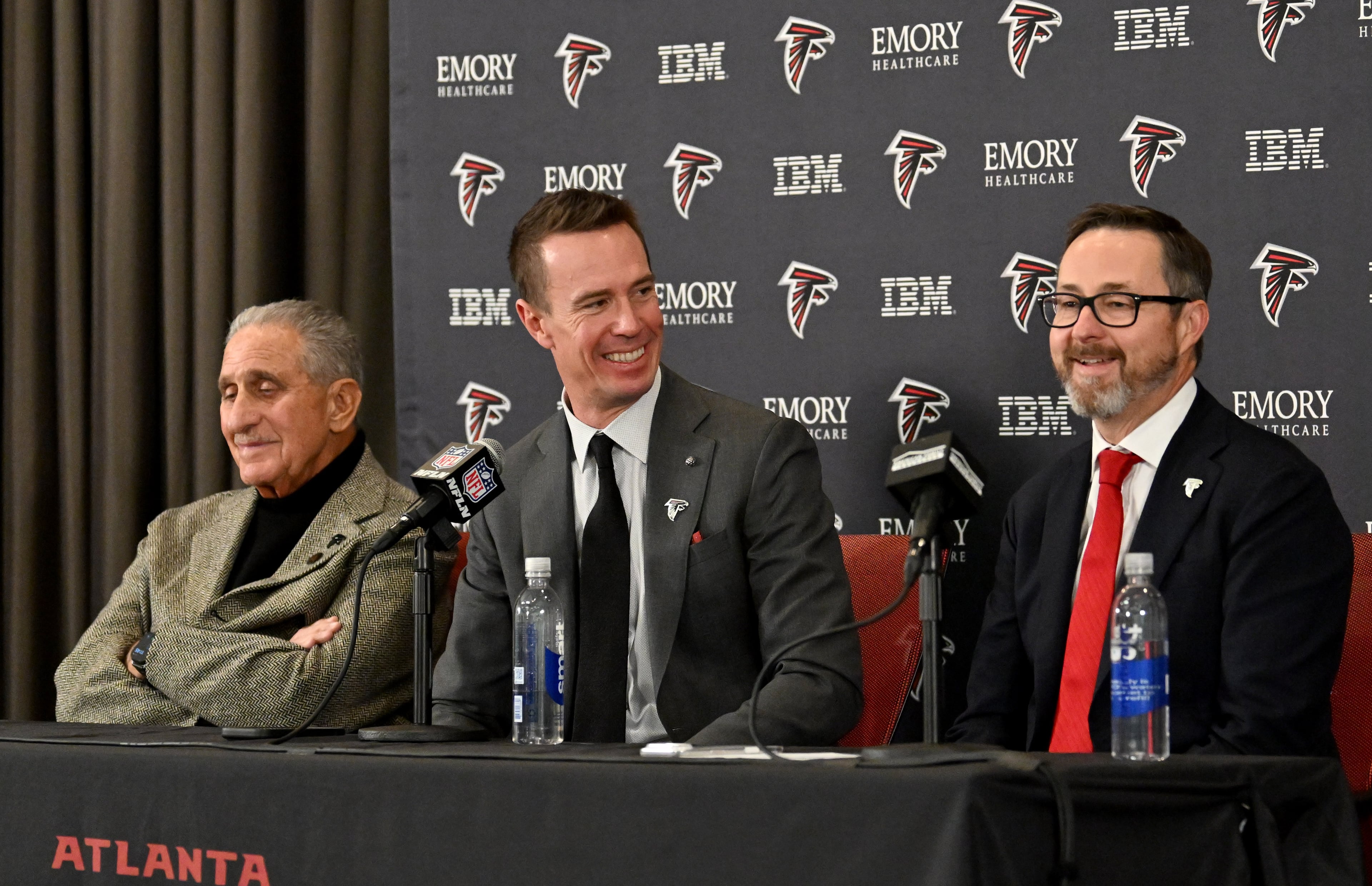 New Atlanta Falcons president of football Matt Ryan reacts as CEO Greg Beadles (right) speaks during a news conference to introduce new Falcons president of football Matt Ryan, Tuesday, Jan. 13, 2026, in Flowery Branch. (Hyosub Shin/AJC)