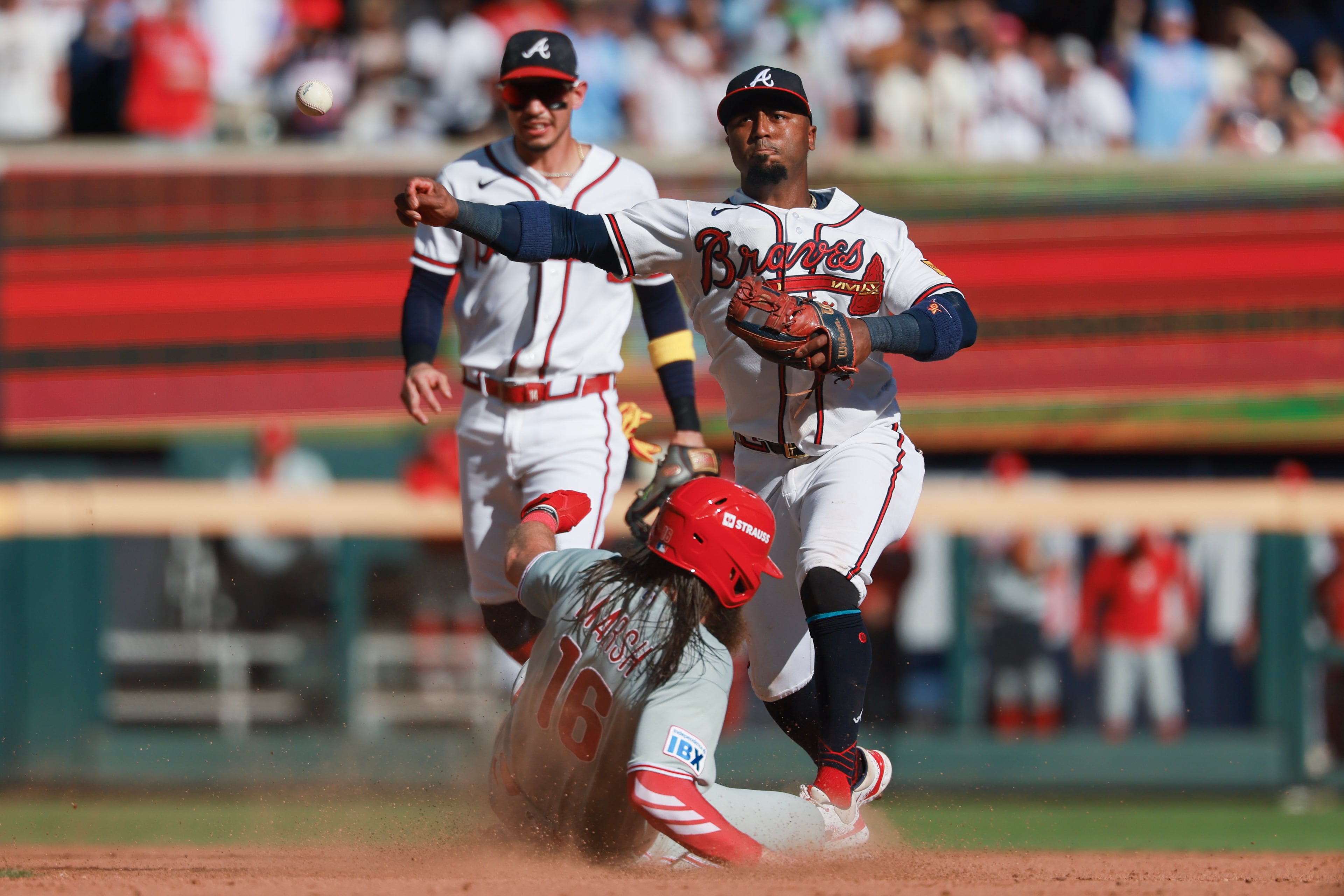 Atlanta Braves second baseman Ozzie Albies, right, turns a double play against Philadelphia PhilliesÕ Brandon Marsh (16) during the ninth inning of Game 1 of a MLB National League Wild Card playoff series between the Atlanta Braves and the Philadelphia Phillies, Tuesday, Sept. 29, 2026, in Atlanta. (Jason Getz/AJC)