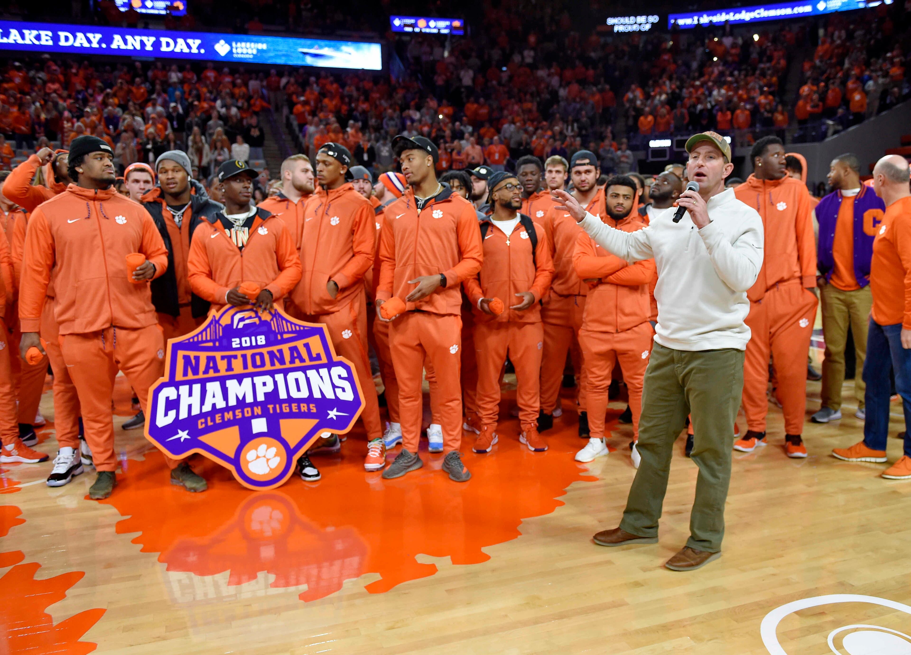 Clemson head football coach Dabo Swinney along with members of the 2019 National Championship football team address the crowd during the first half of an NCAA college basketball game between Clemson and Virginia, Saturday, Jan. 12, 2019, in Clemson, S.C. (AP Photo/Richard Shiro)