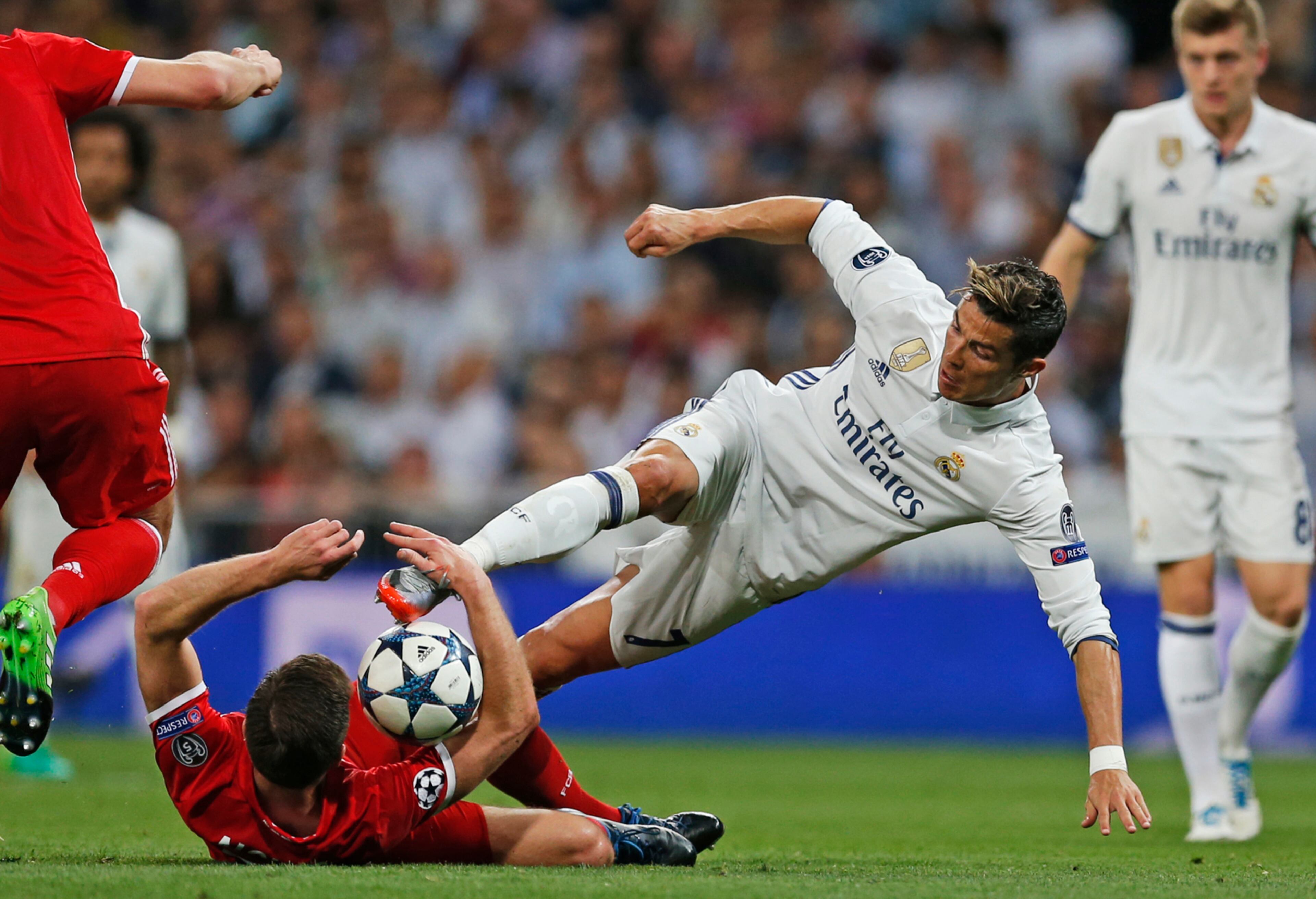 Real Madrid's Cristiano Ronaldo, center, and Bayern's Xabi Alonso, bottom, vie for the ball during the Champions League quarterfinal second leg soccer match between Real Madrid and Bayern Munich at Santiago Bernabeu stadium in Madrid, Spain, Tuesday April 18, 2017. (AP Photo/Francisco Seco)